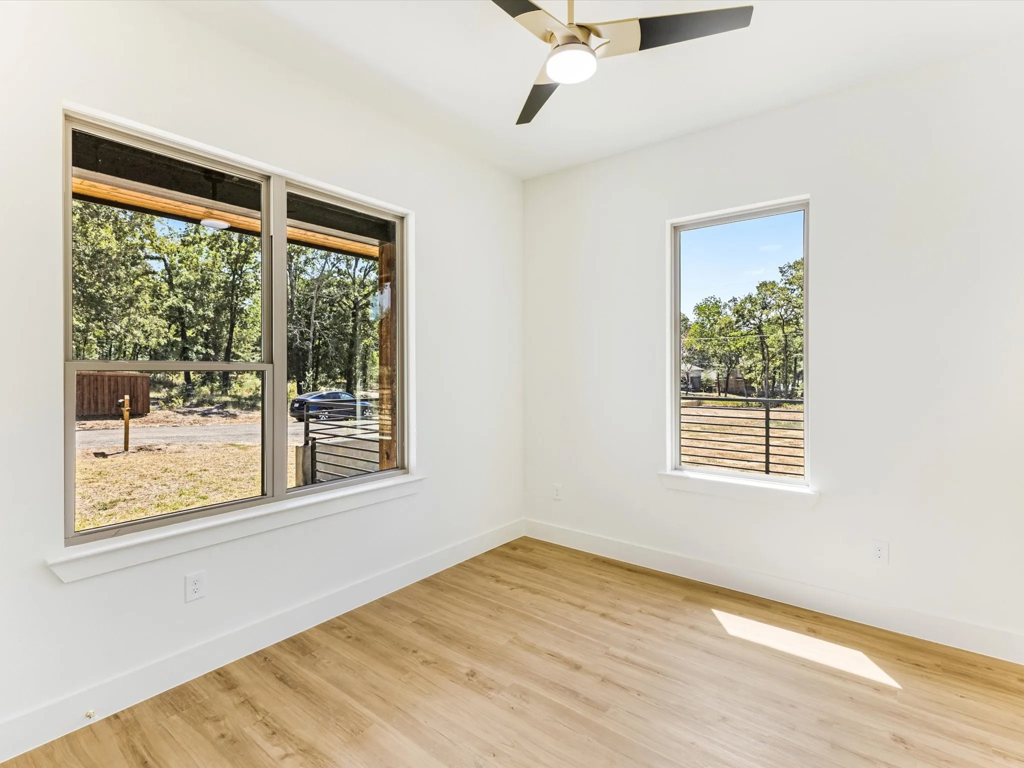 Wood-finish flooring, white walls, and a contemporary ceiling fan