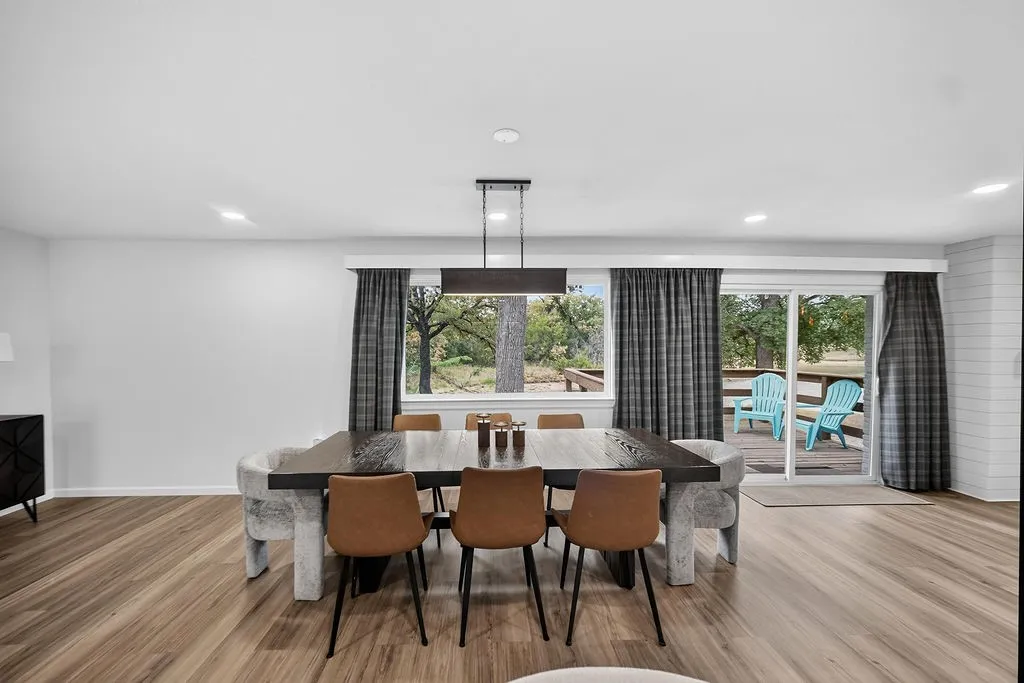 Wood-finish flooring, recessed lighting, expansive window, sliding glass door, and a shiplap accent wall