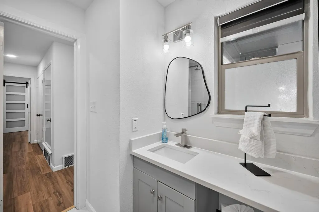 Modern vanity with a rectangular undermount sink, contemporary faucet, and quartz countertop