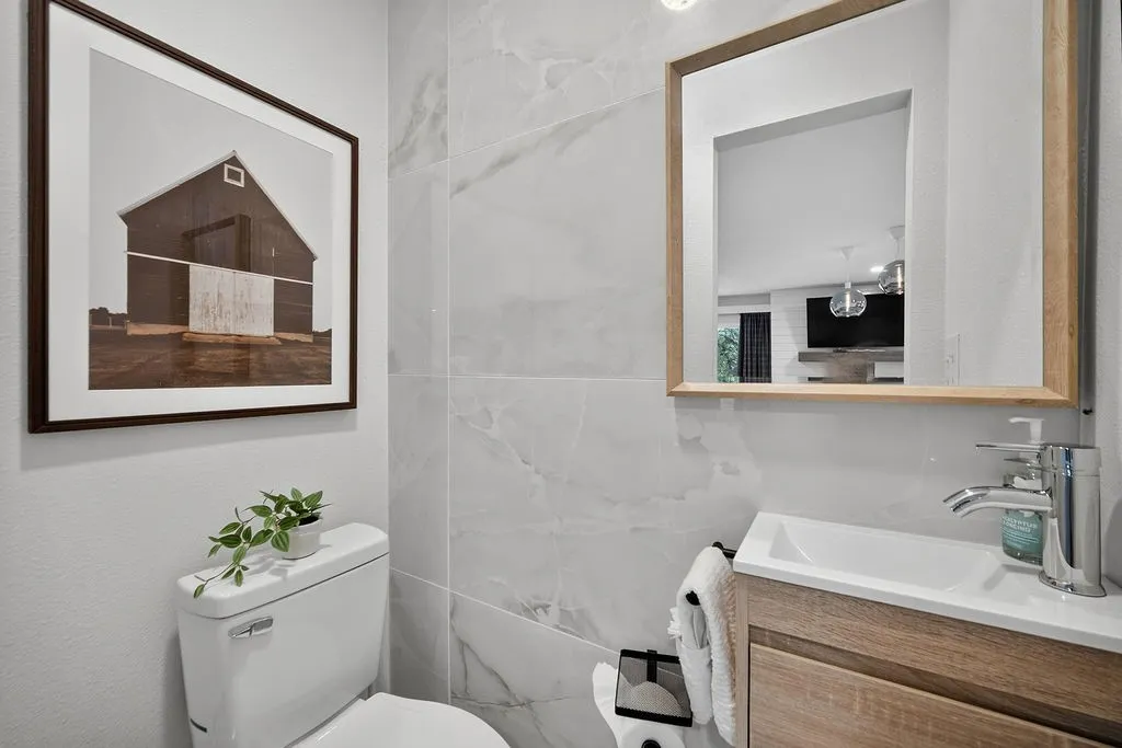 White wall-mounted toilet with a chrome flush lever