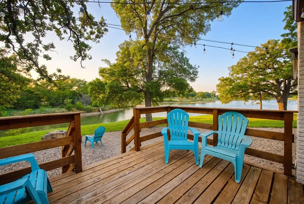 Expansive wooden deck with a built-in railing, overlooking a tranquil body of water