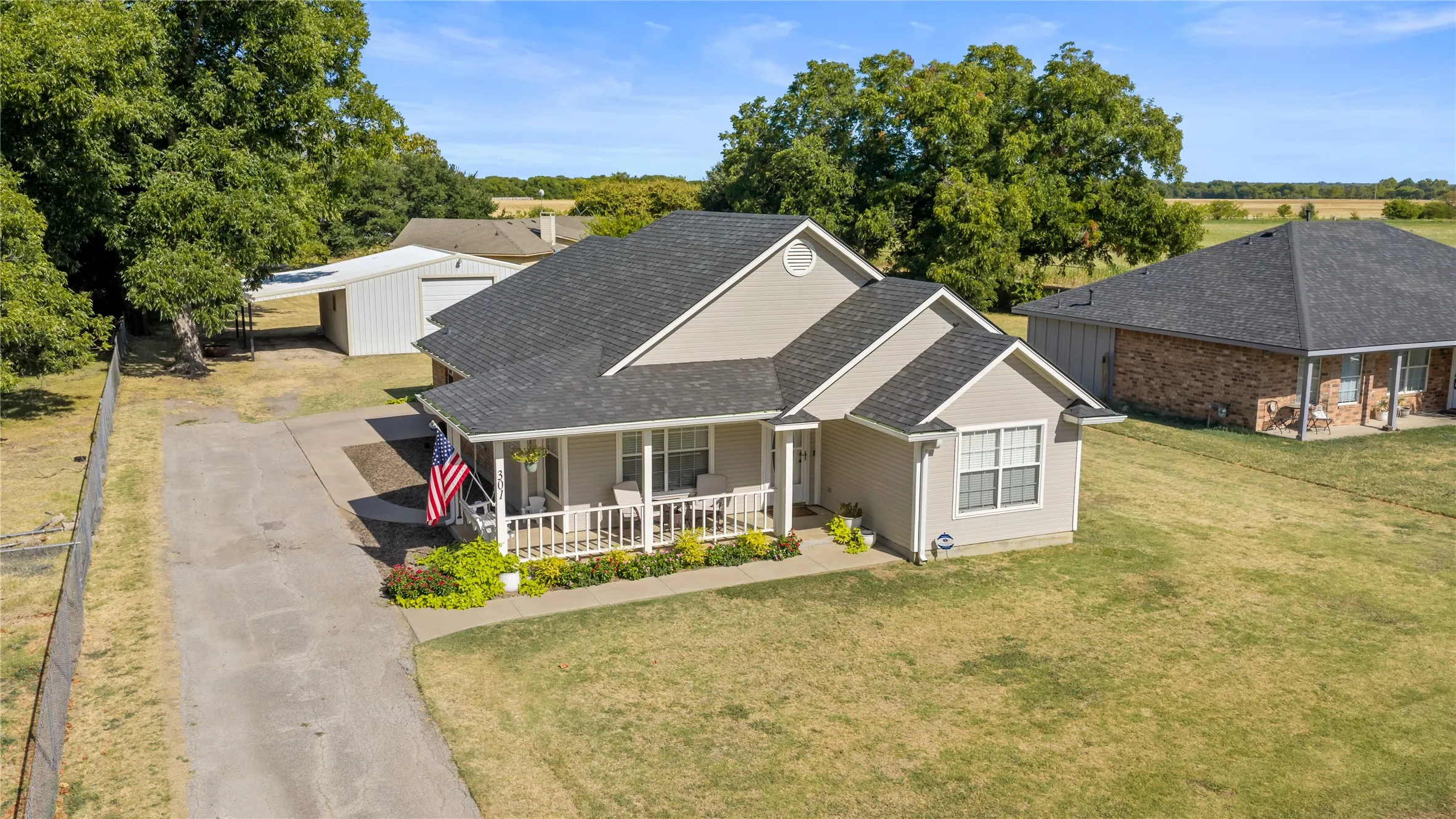 Charming curb appeal with inviting front porch and mature landscaping.