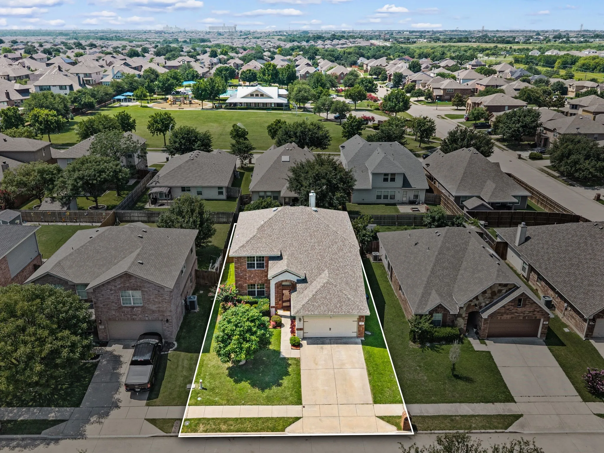 Brick exterior residence with an attached garage, featuring a concrete driveway and a manicured lawn
