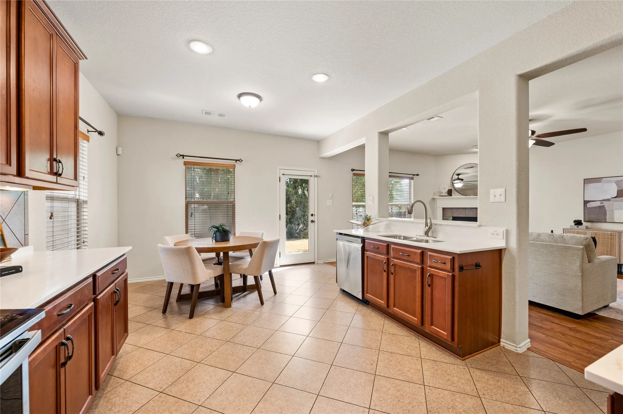 Kitchen featuring tile flooring, white countertops, wood cabinetry, and stainless steel appliances