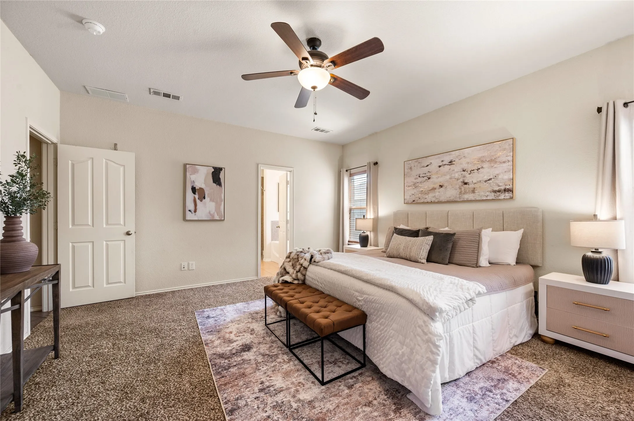 Plush carpet flooring, neutral wall tones, window treatments, and a ceiling fan with integrated lighting