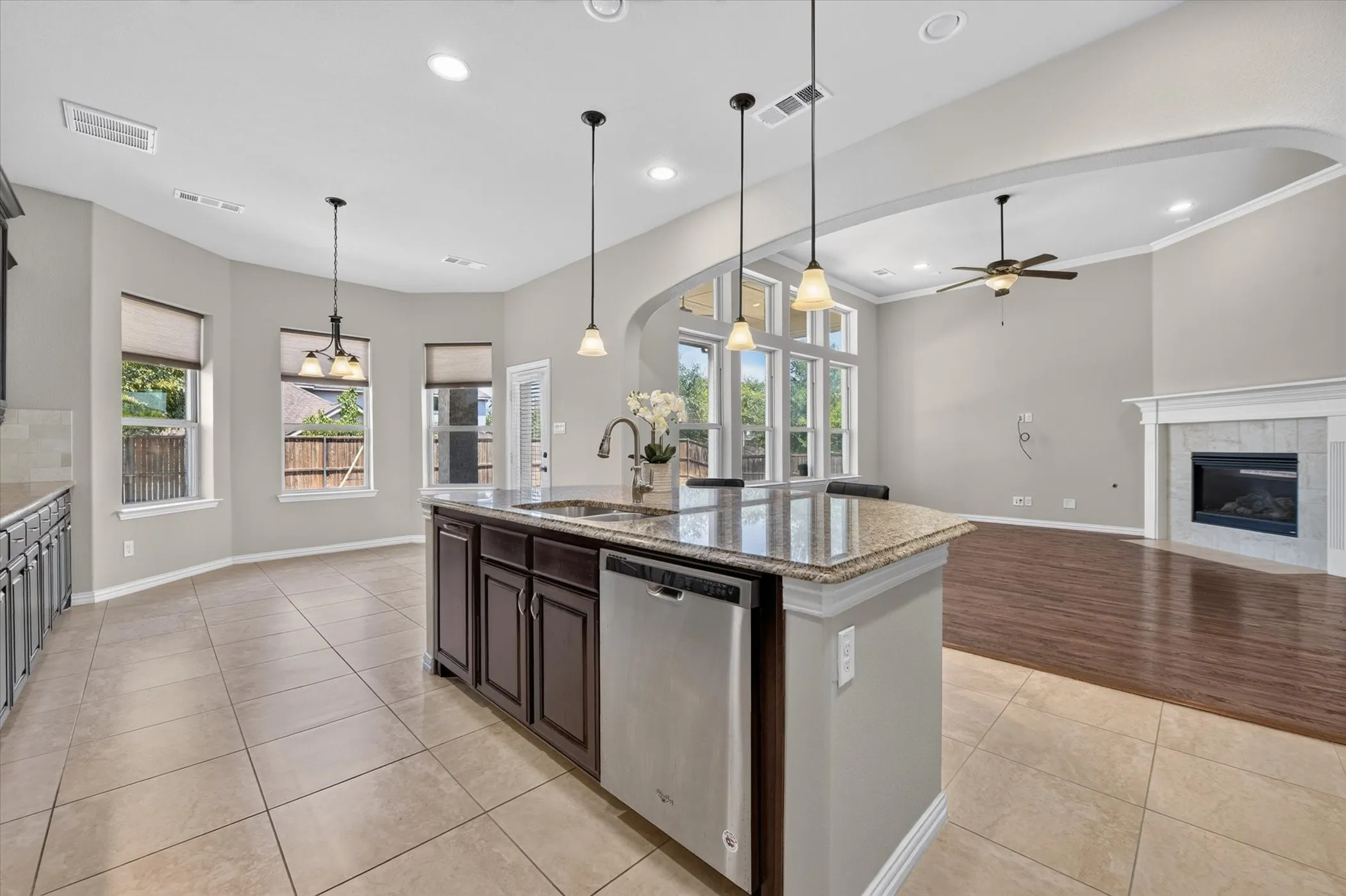 Kitchen island with granite countertop, integrated sink, and stainless steel dishwasher