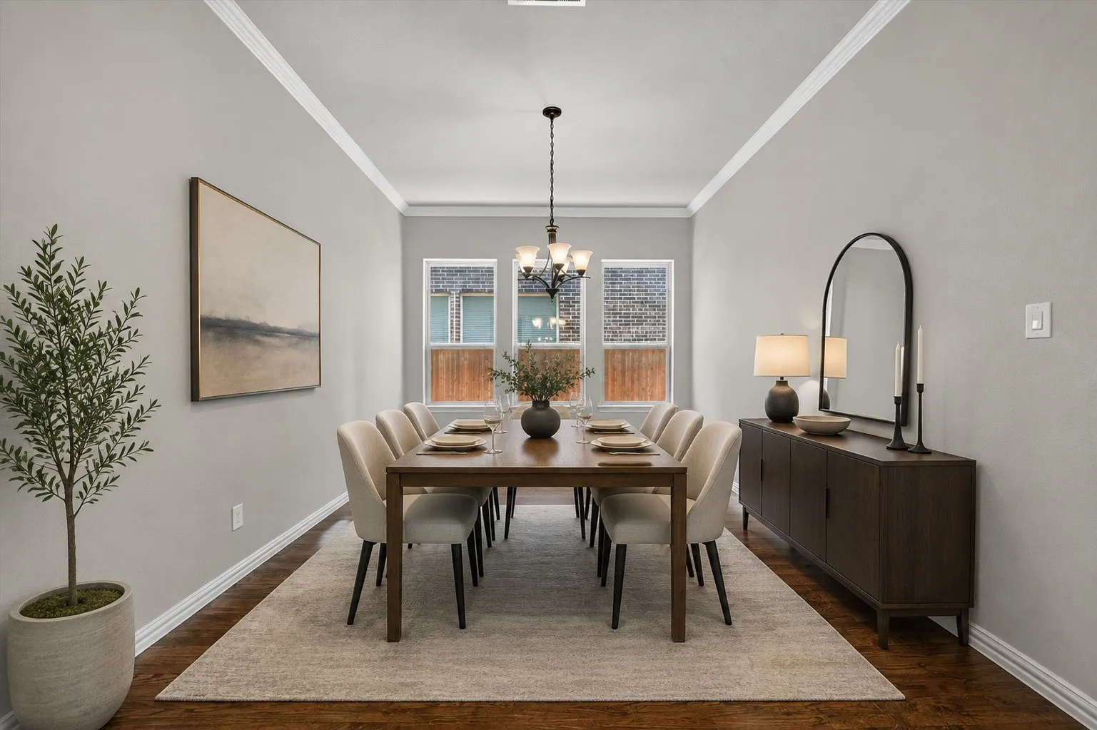 Virtually staged. Wood-finish flooring with crown molding and white trim