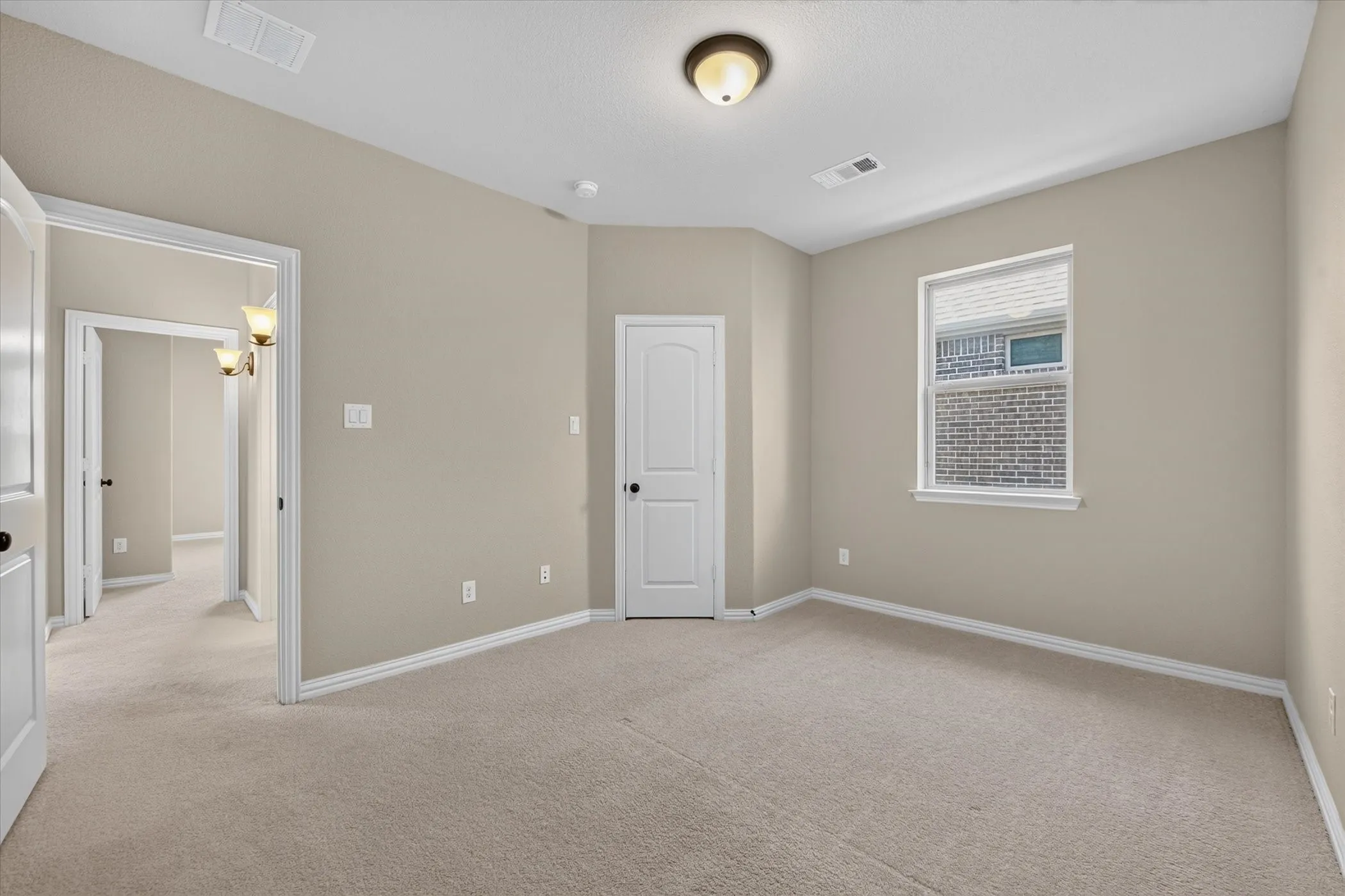 Neutral wall color, carpeted flooring, window with blinds, ceiling-mounted light fixture, white interior doors