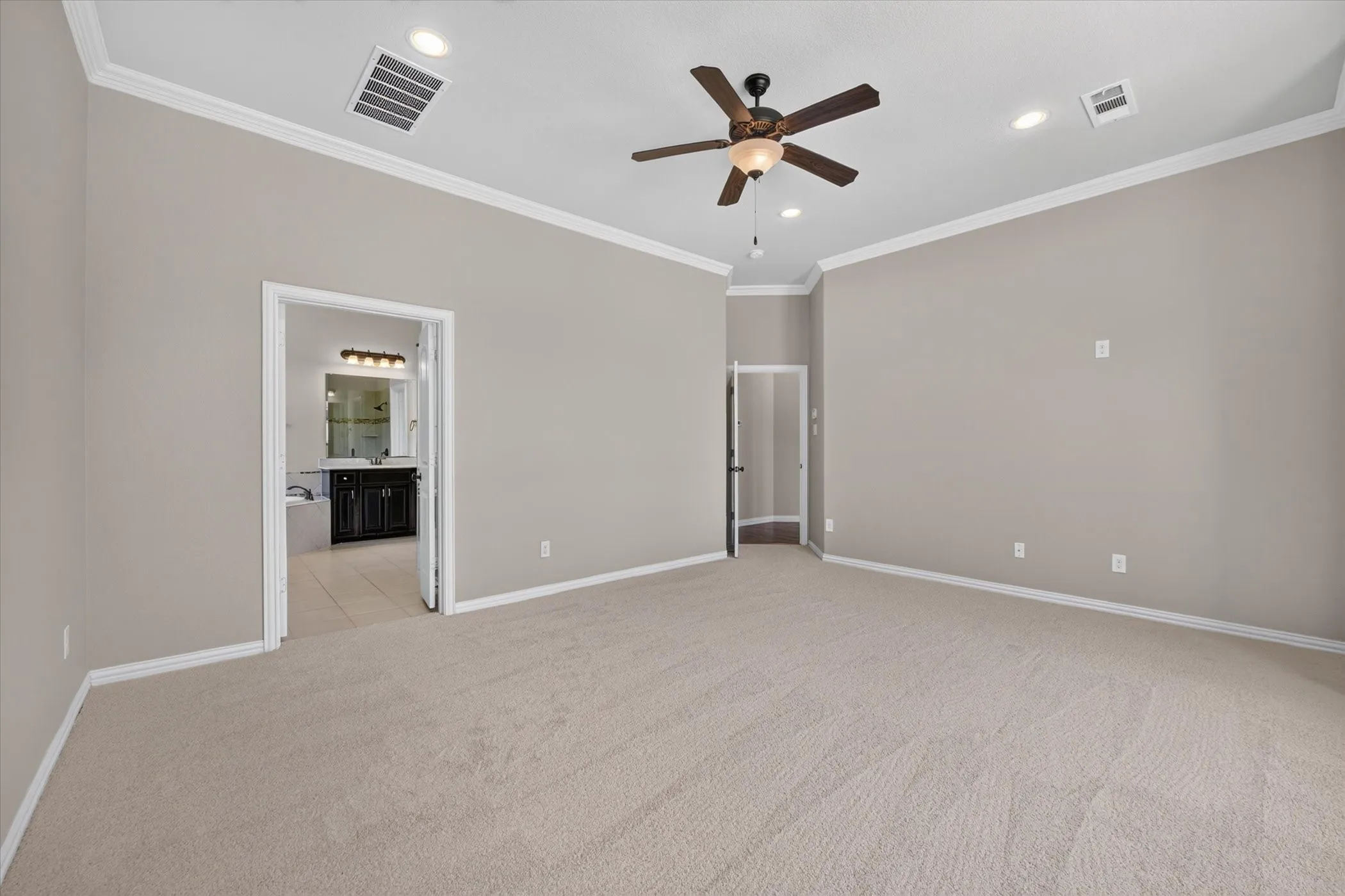 Vaulted ceiling with recessed lighting, ceiling fan, and crown molding