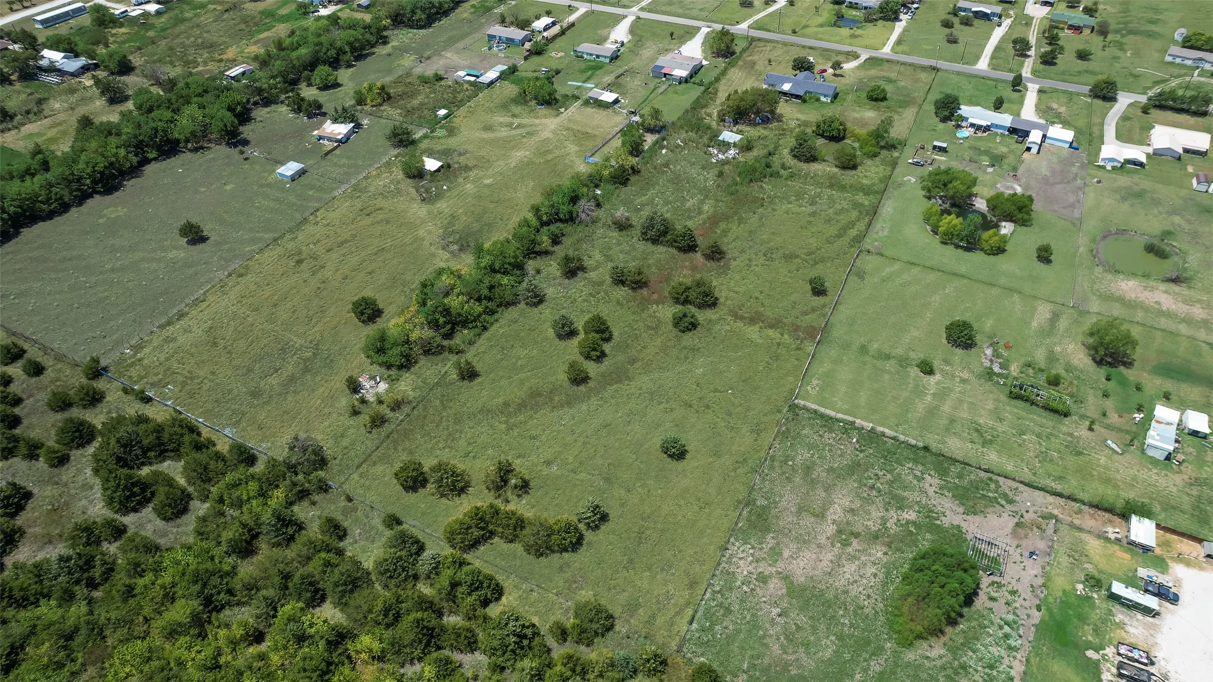 Expansive land parcel featuring natural tree cover and open grassy areas