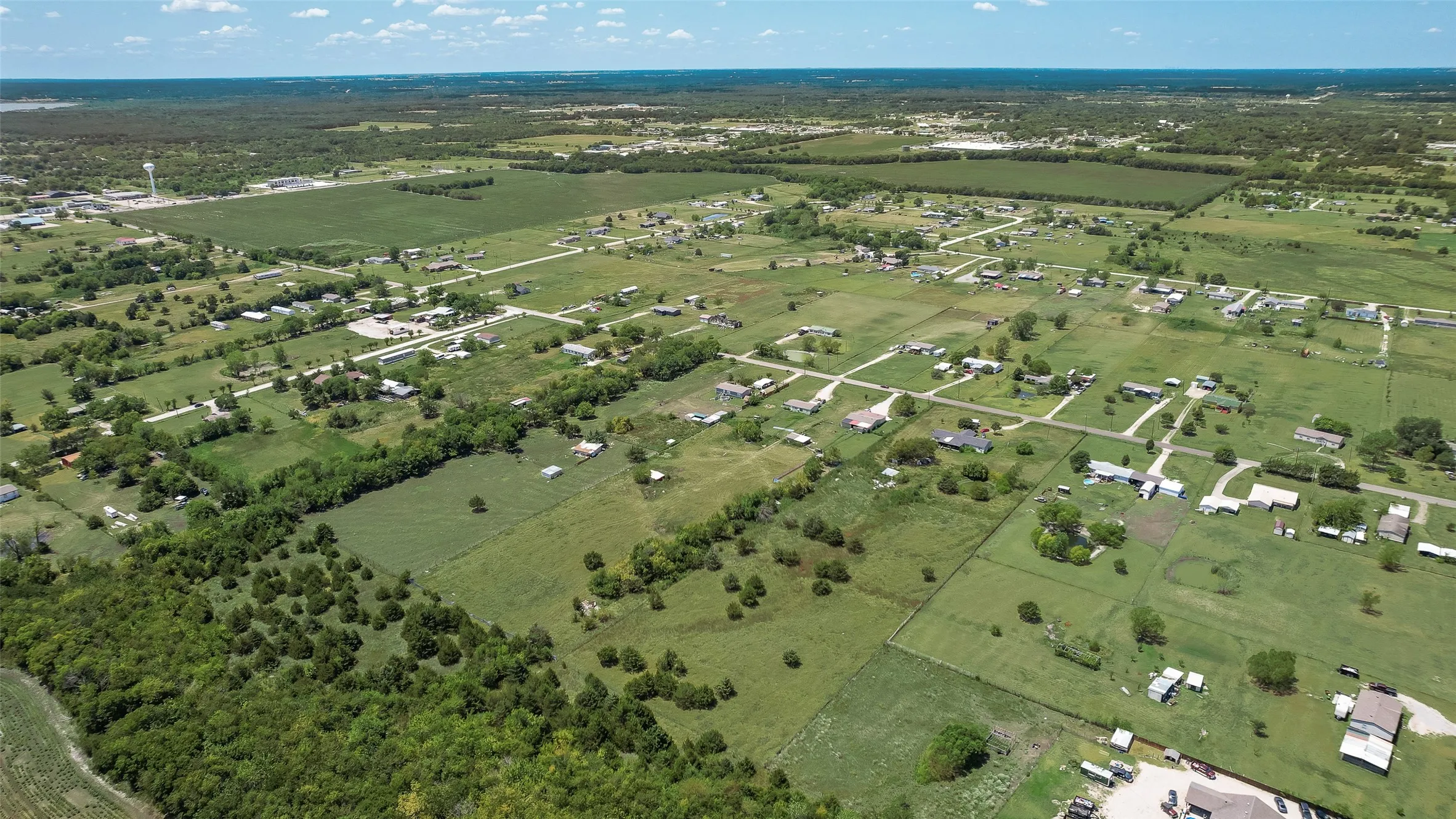 Expansive land parcel with surrounding agricultural fields and scattered residential properties