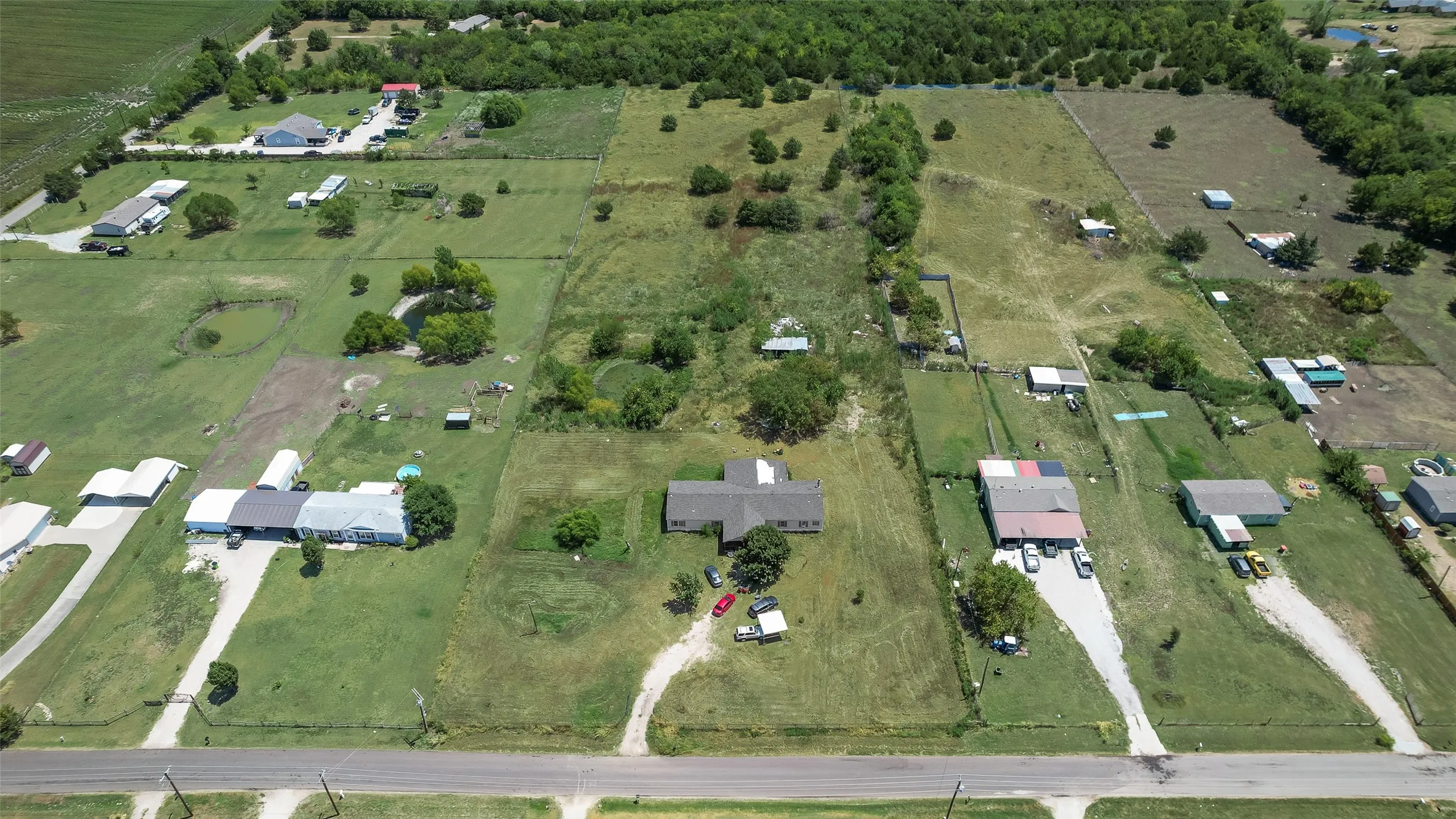 Expansive property with multiple buildings, vast green spaces, and established trees