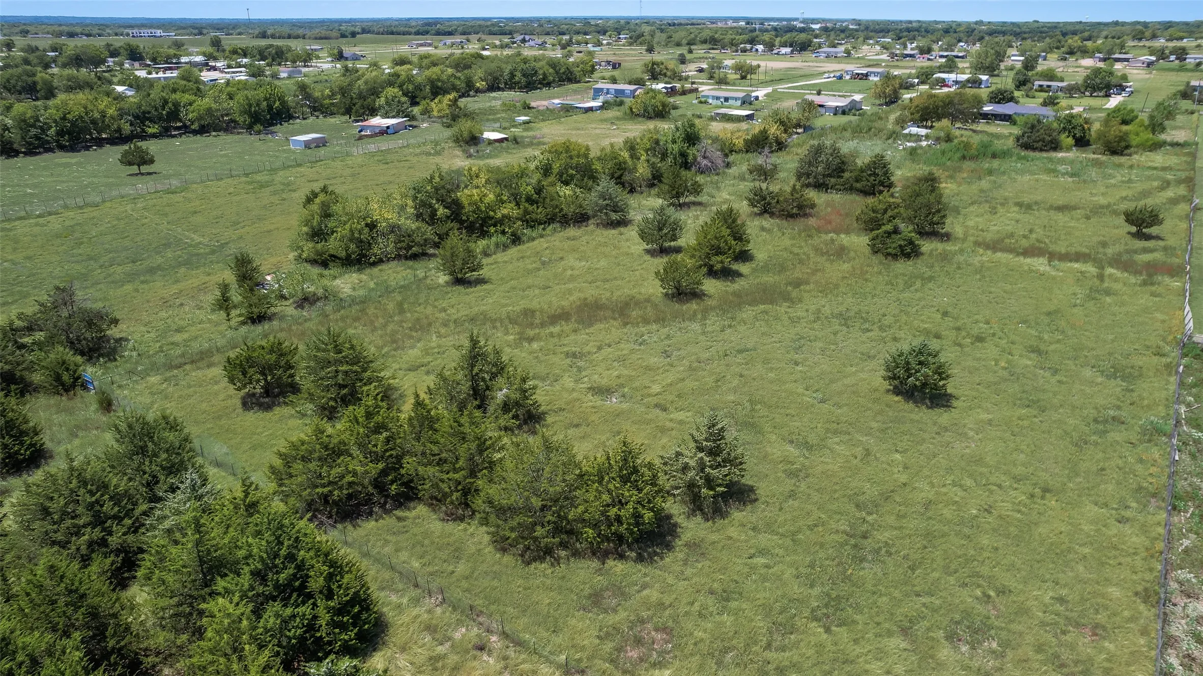 Expansive land parcel featuring open fields and scattered trees
