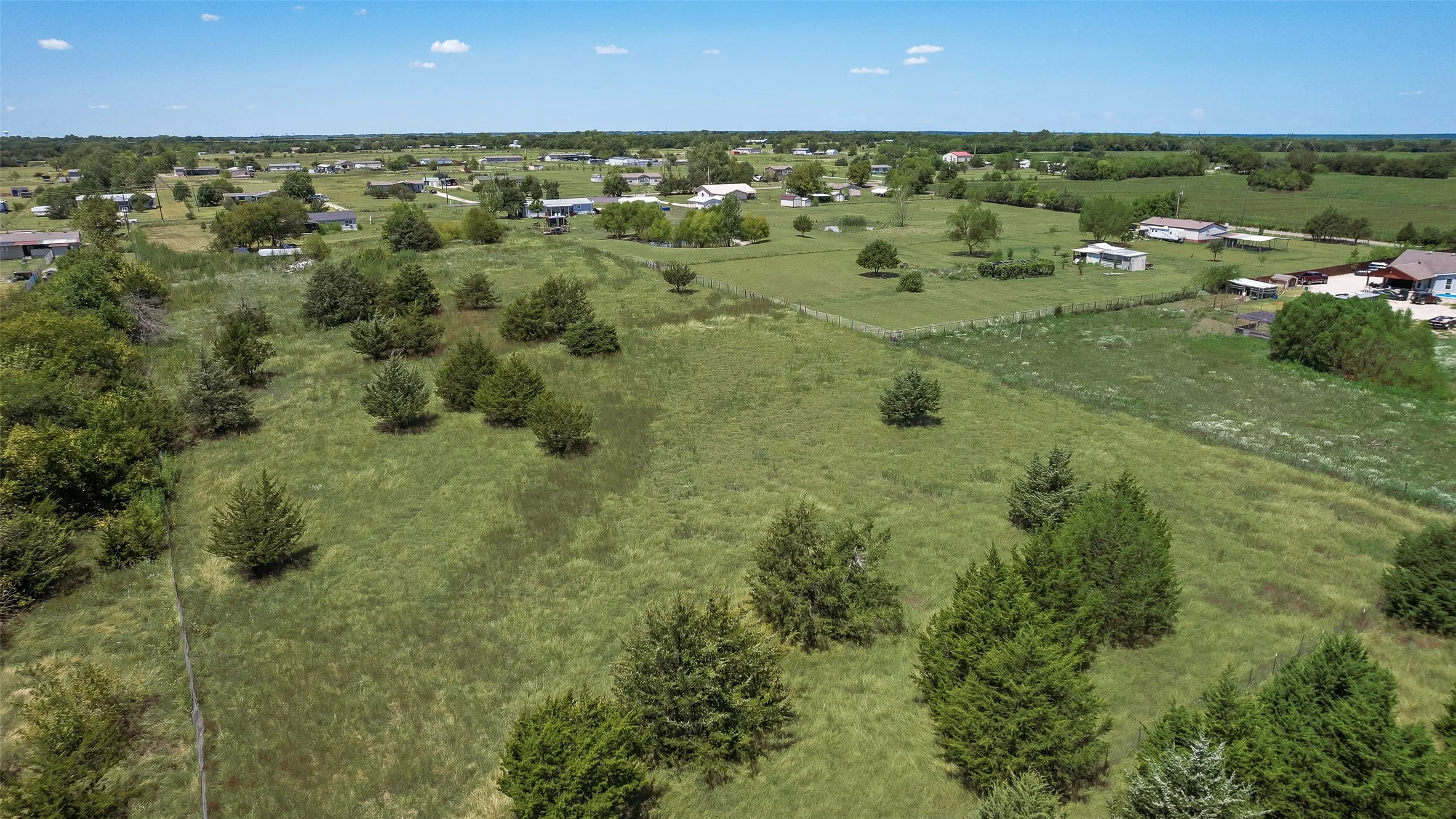 Expansive green landscape with scattered trees