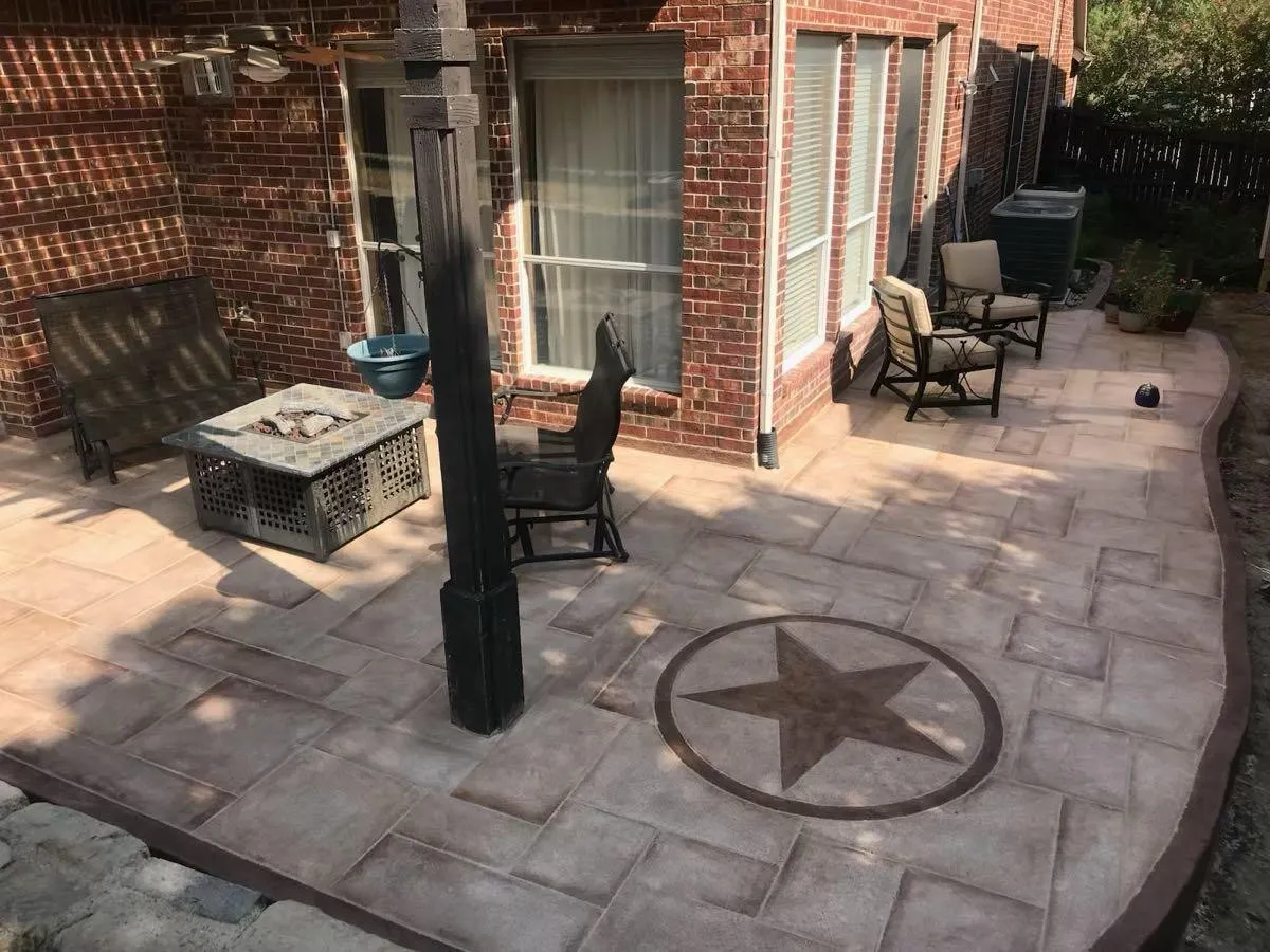 Expansive patio featuring a decorative star inlay, brick exterior, and a built-in ceiling fan