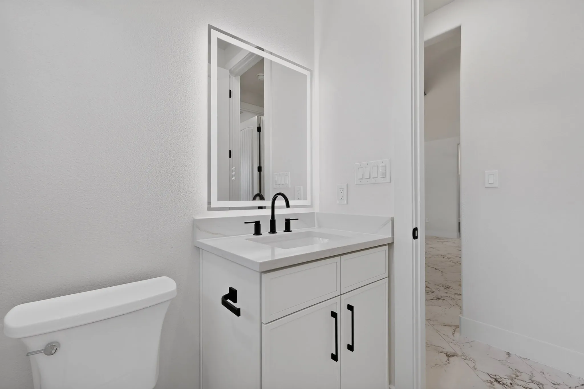 White vanity with integrated rectangular sink and matte black faucet