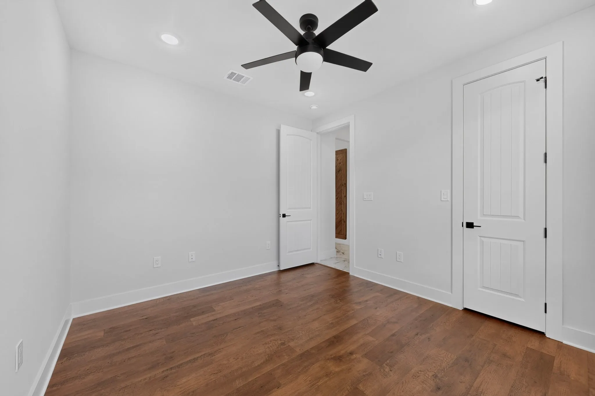 Wood-finish flooring, recessed lighting, and a ceiling fan with integrated lighting