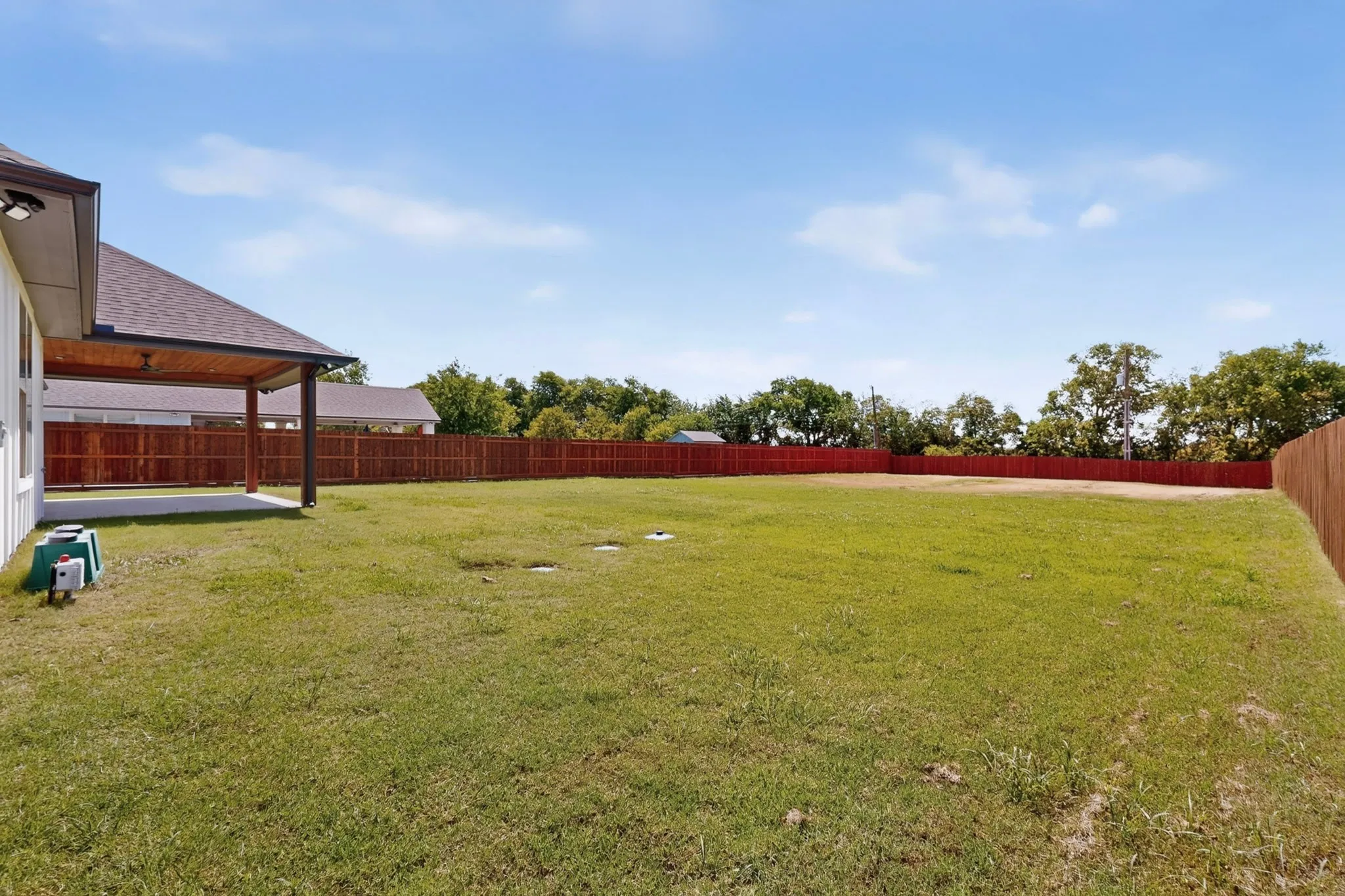 Expansive grass lawn with a wood privacy fence