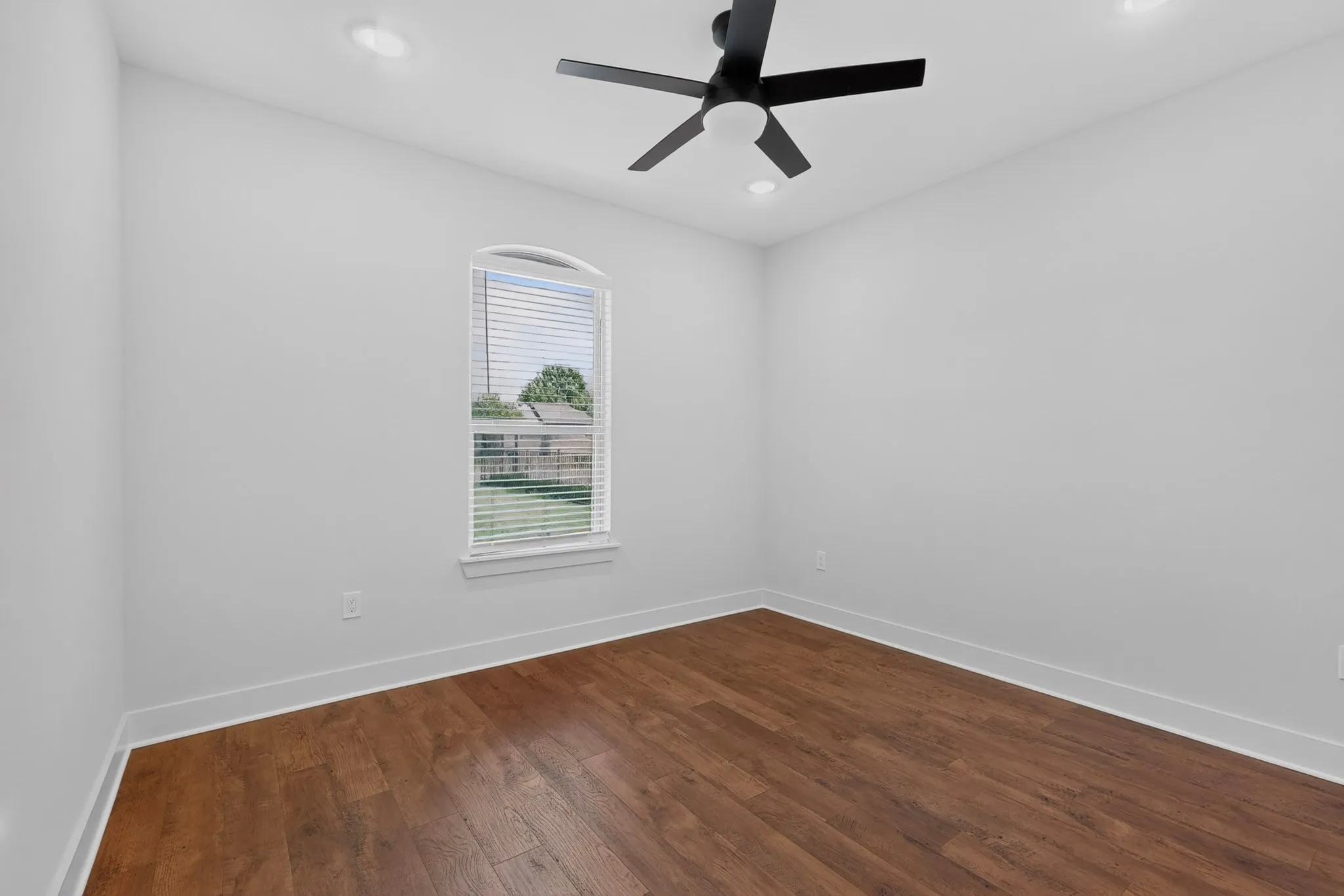 Recessed lighting, wood-finish flooring, and a modern ceiling fan with a matte black finish