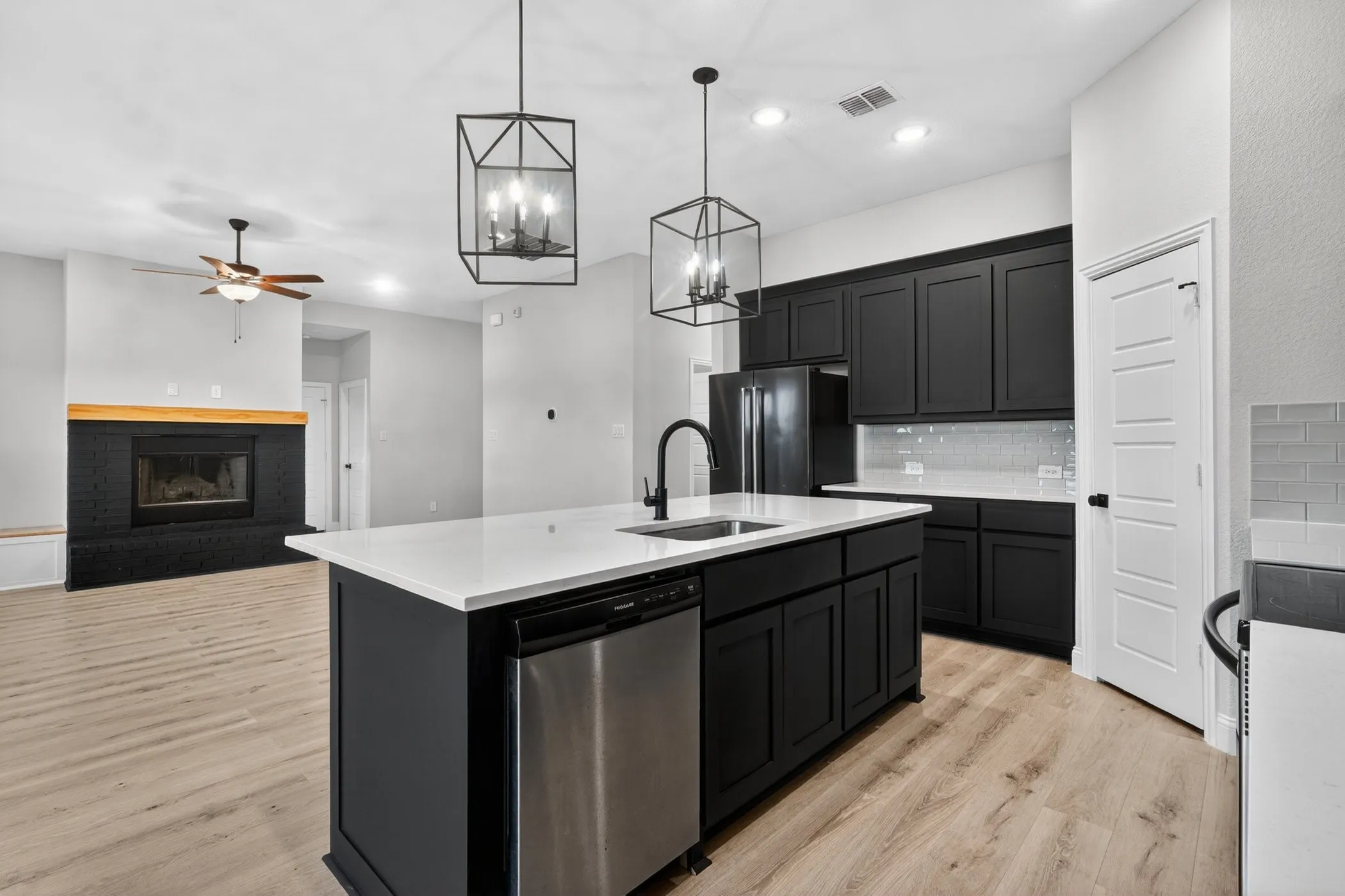 Kitchen island with an undermount sink, a stainless steel dishwasher, and a white countertop
