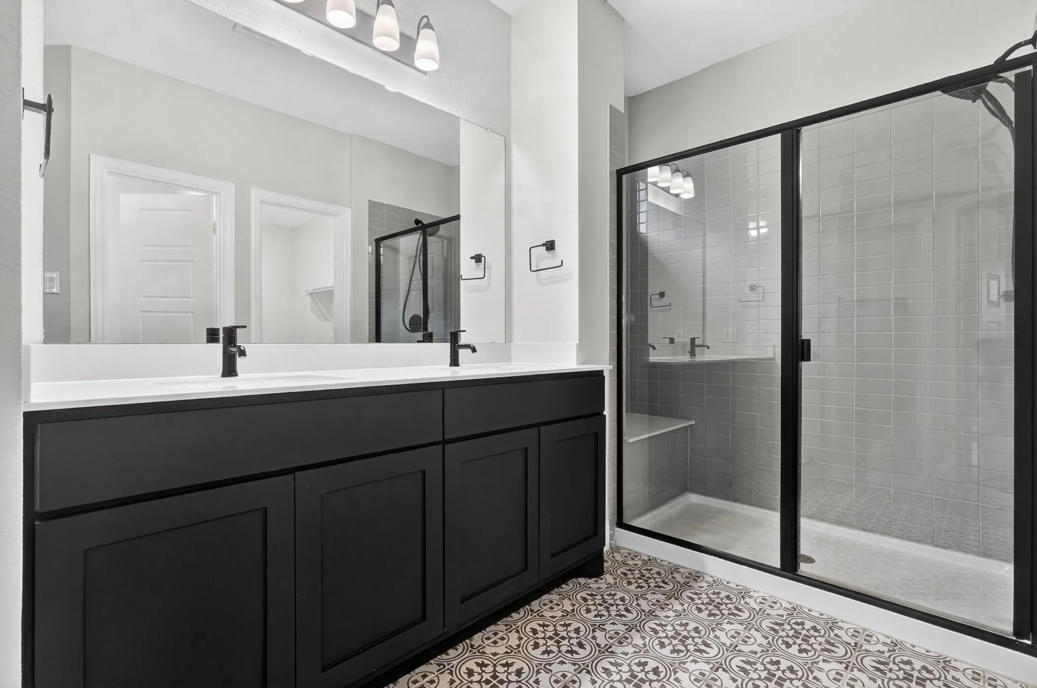 Dual vanity with white countertop, matte black fixtures, and integrated sinks