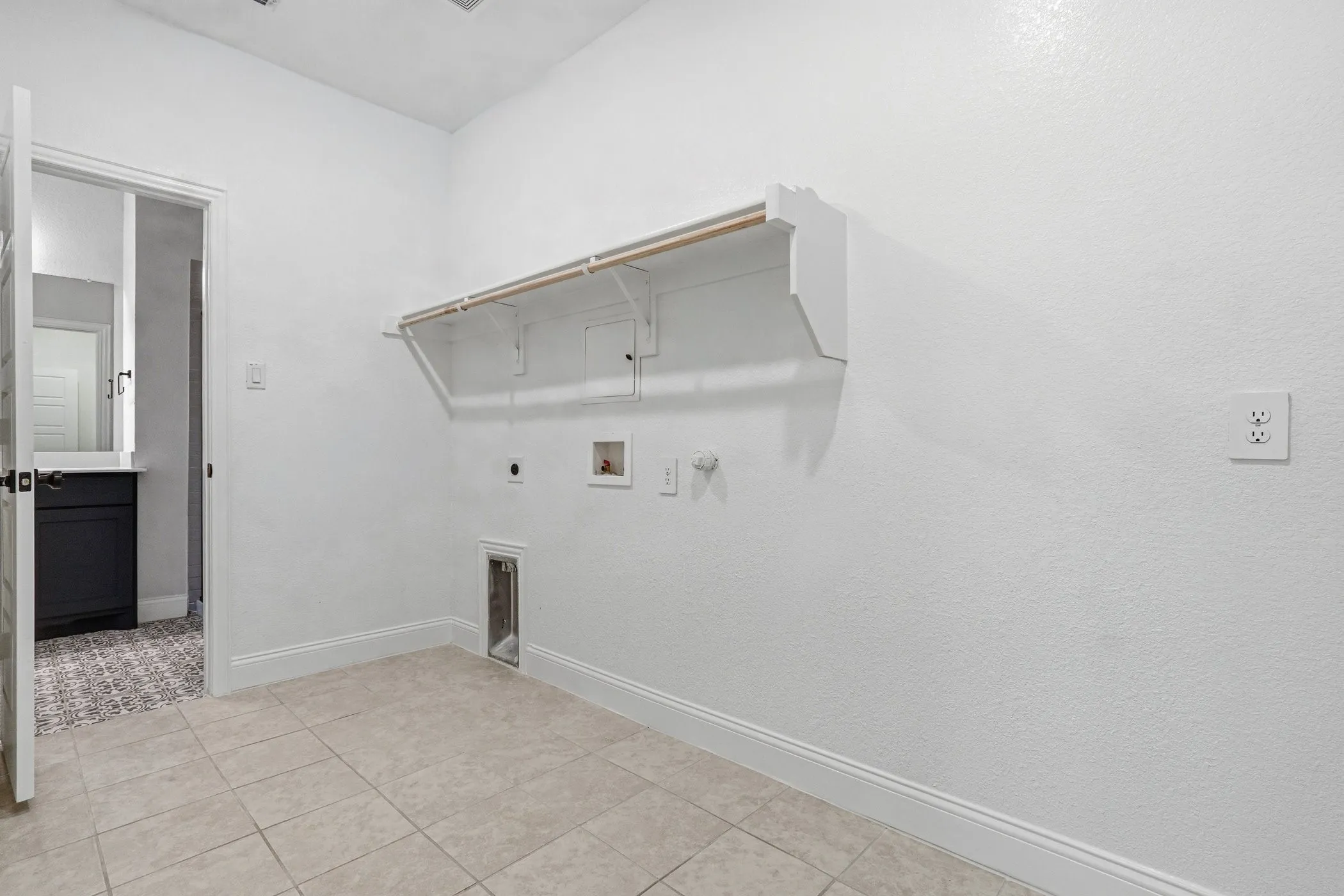 Tile flooring, white walls, and built-in shelving with hanging rod