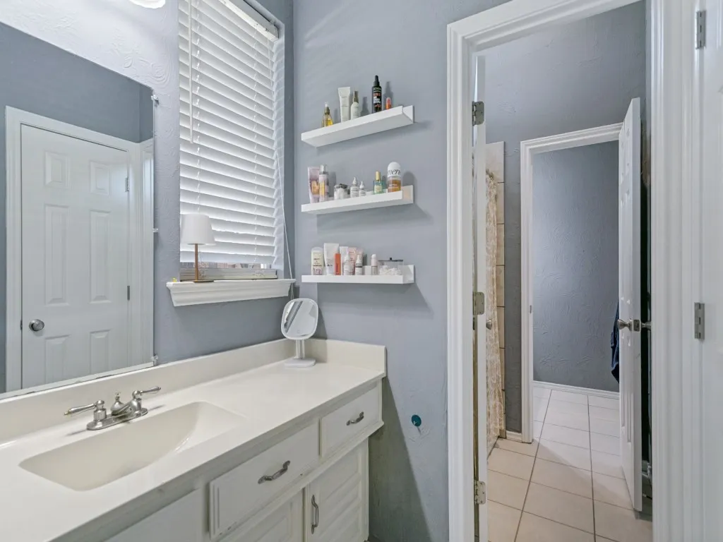 This jack and jill bath between secondary bedrooms provides separate vanities and closets with a shared shower between.