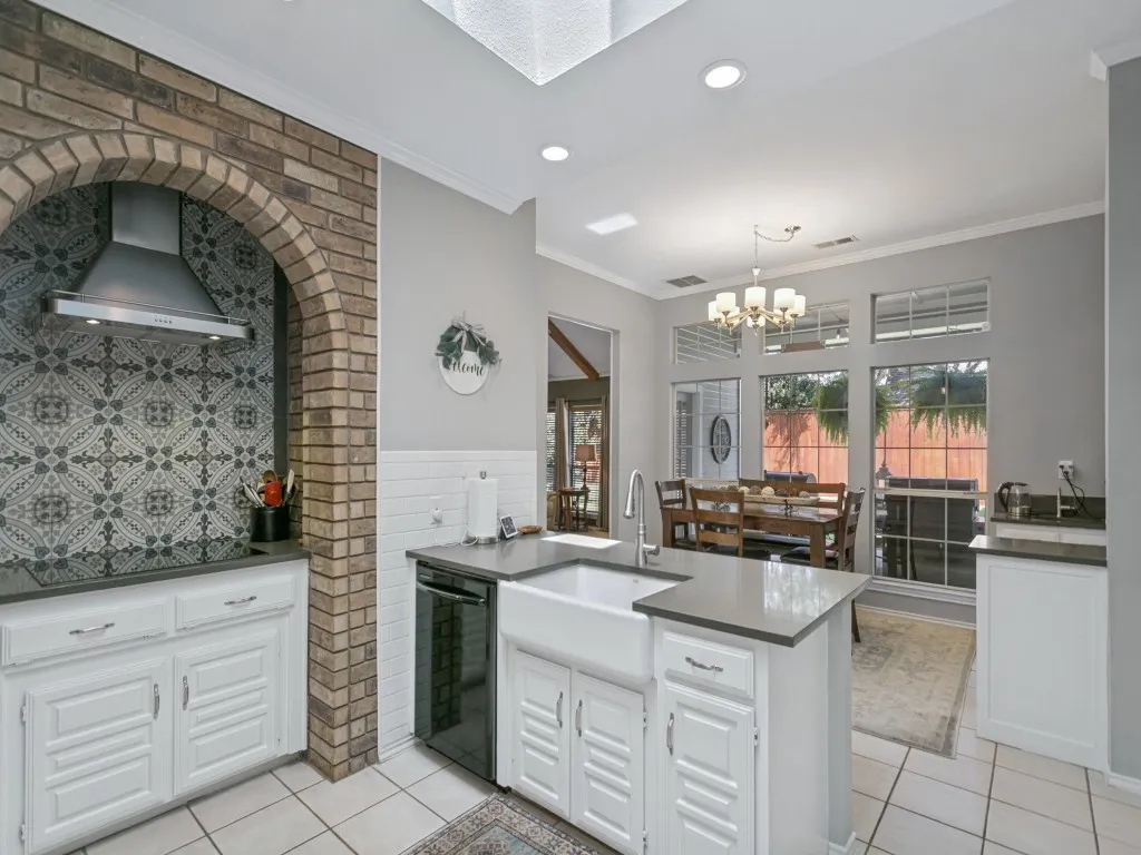 Great detailing in the kitchen from the farmhouse sink to the cooktop accent backsplash.