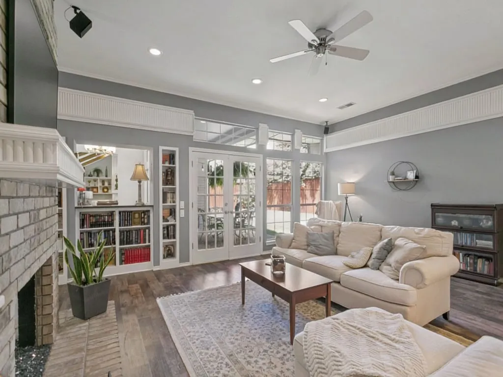Living area features a double-sided brick fireplace, tons of built-in shelving and great backyard views.