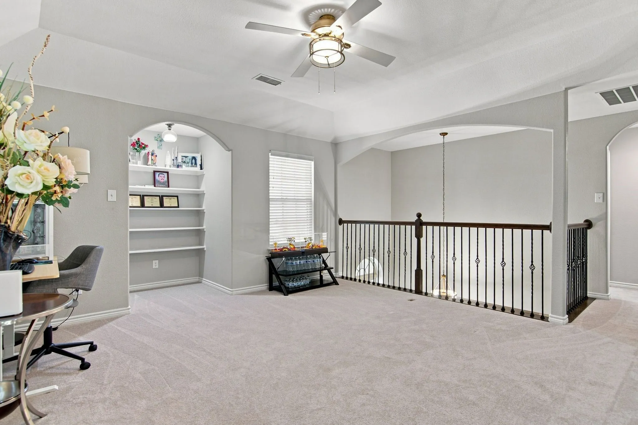 Spacious loft-style bedroom with soaring ceilings, ceiling fan with integrated lighting, and plush carpeting throughout