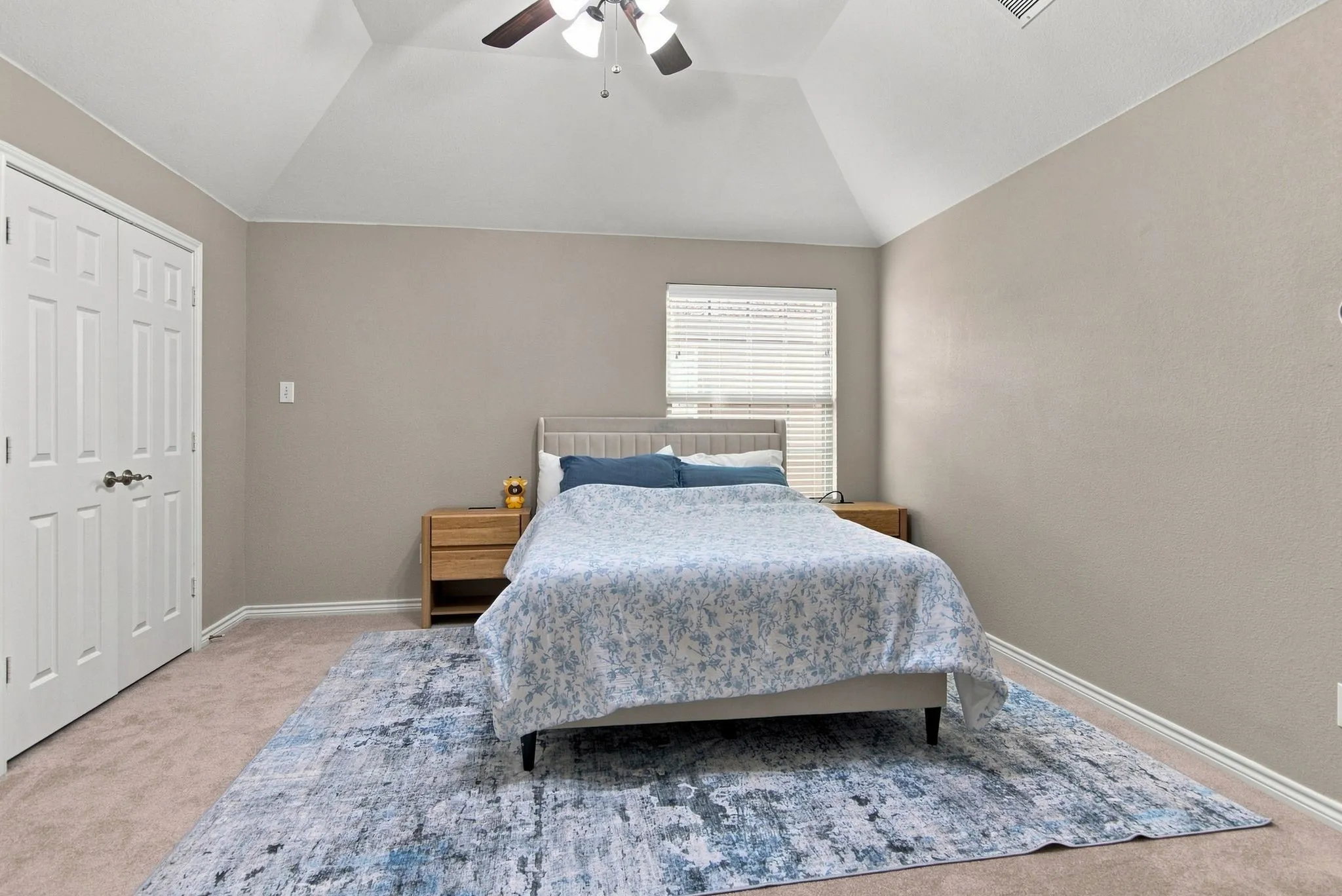 Tray ceiling, ceiling fan with light, neutral wall paint, carpet flooring, and white bi-fold doors