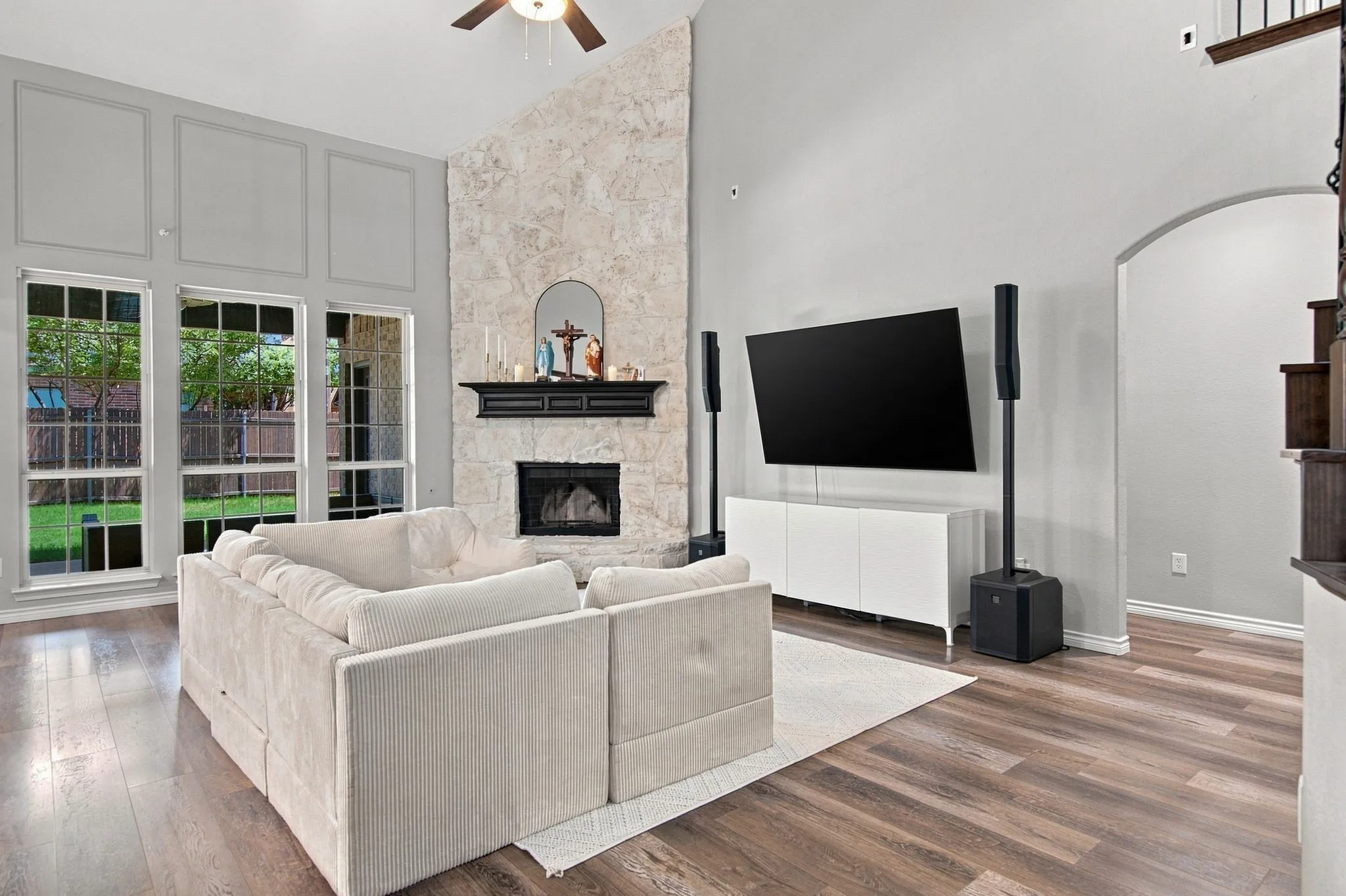 Expansive living area with a stone-clad fireplace and wood mantel