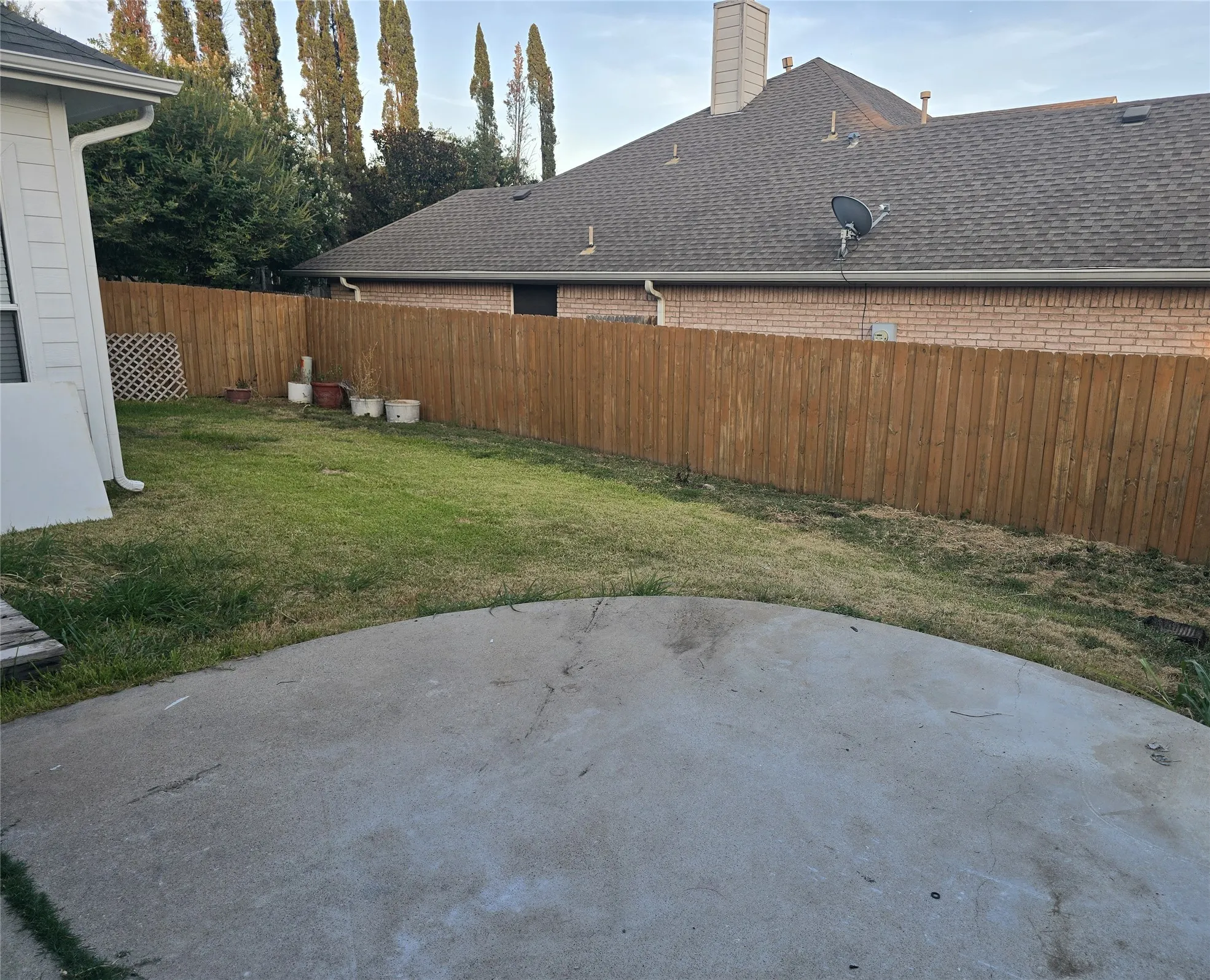Expansive concrete patio with a privacy fence