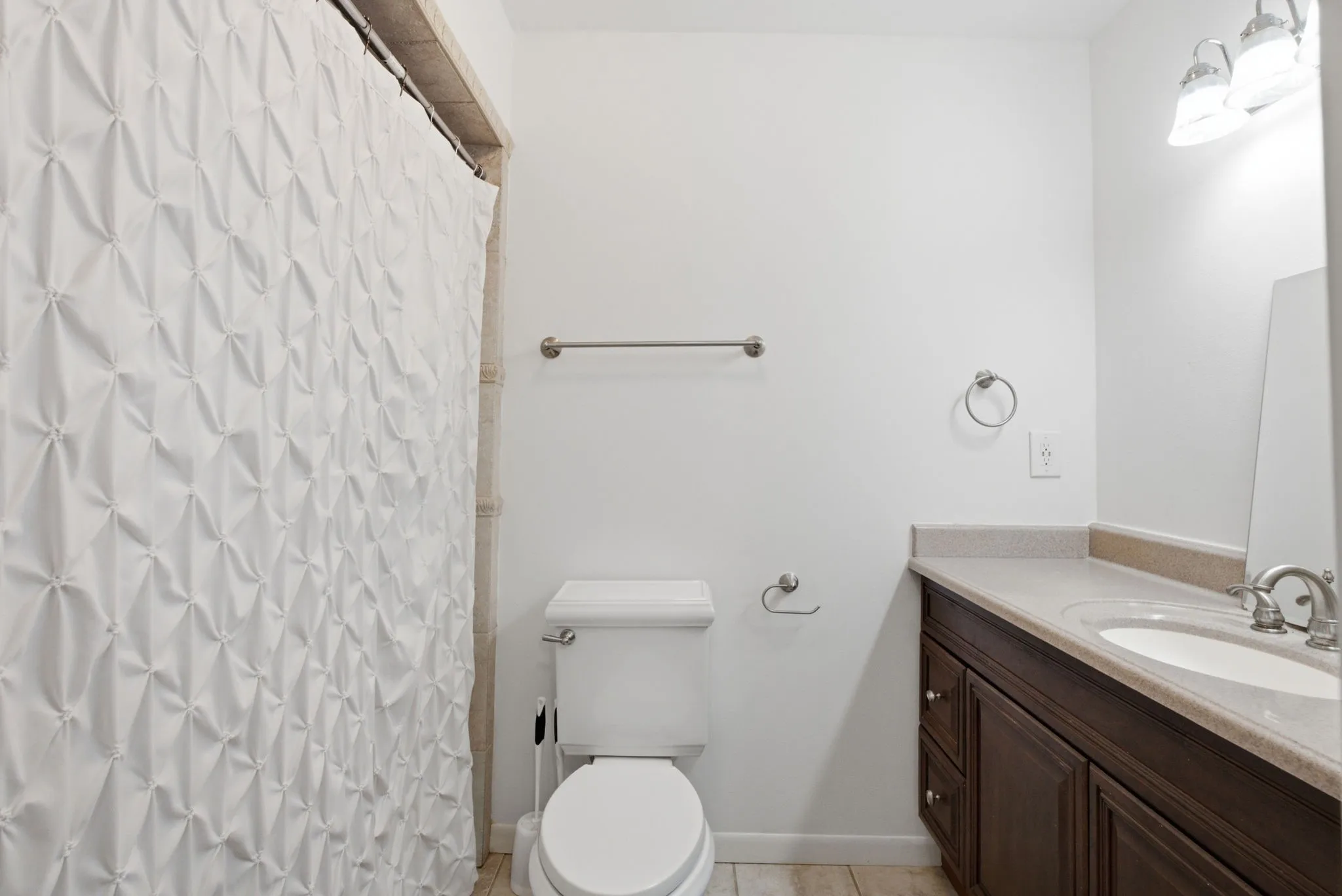 Bathroom featuring a built-in vanity with a countertop, integrated sink, and wood-finish cabinetry