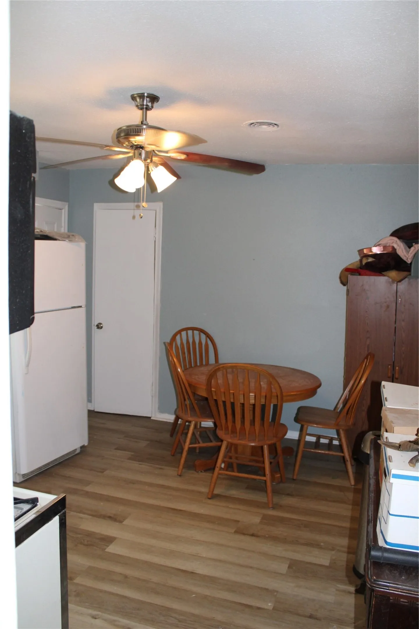 Wood-finish flooring with a satin finish ceiling fan and flush-mounted ceiling light