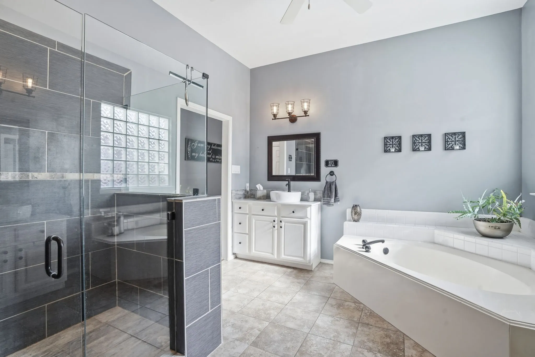 Spacious bathroom featuring a frameless glass shower, a corner jetted soaking tub