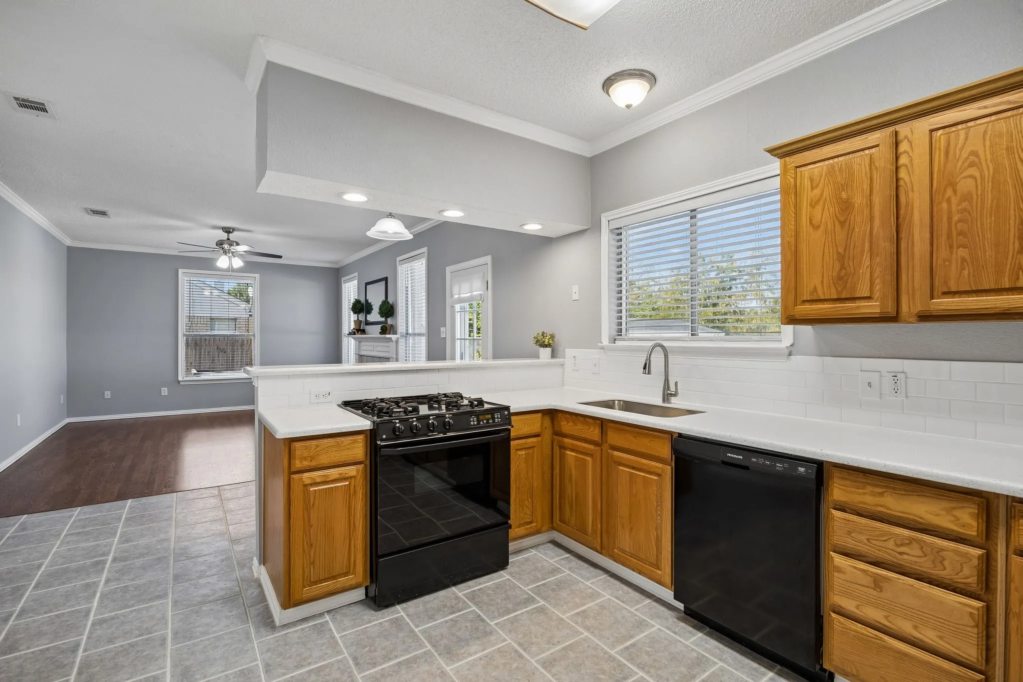 The kitchen has plenty of countertop space, nice breakfast bar, large sink, new countertops, subway tile backsplash, and gas range.