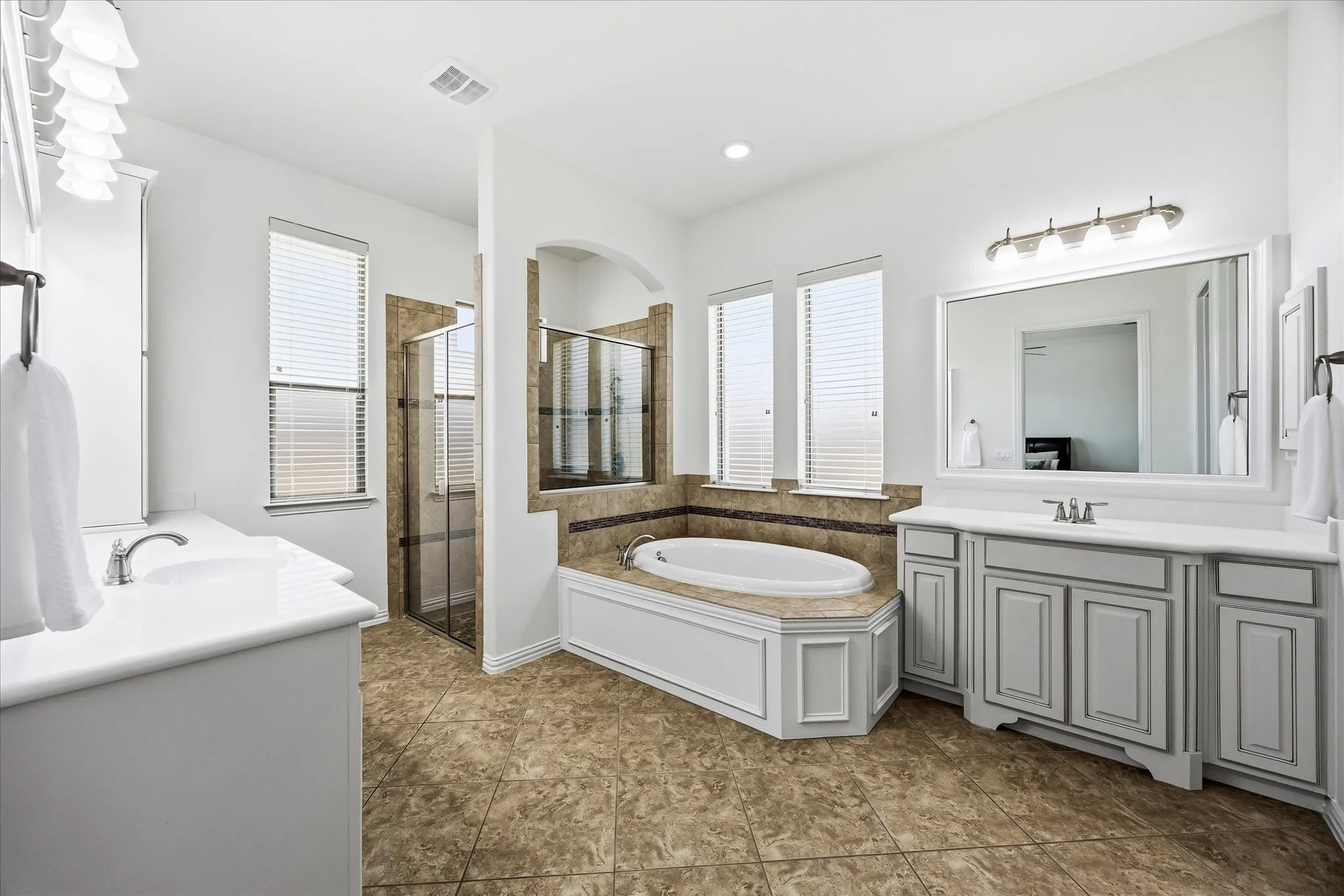 Its spa-like bath includes separate vanities, a deep soaking tub, oversized shower with dual heads and spacious walk-in closet.