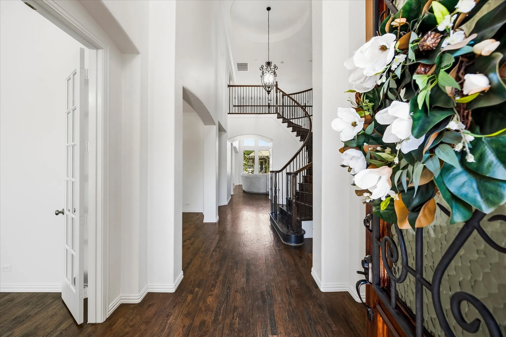 The rotunda foyer showcases a dramatic spiral staircase and soaring ceiling.