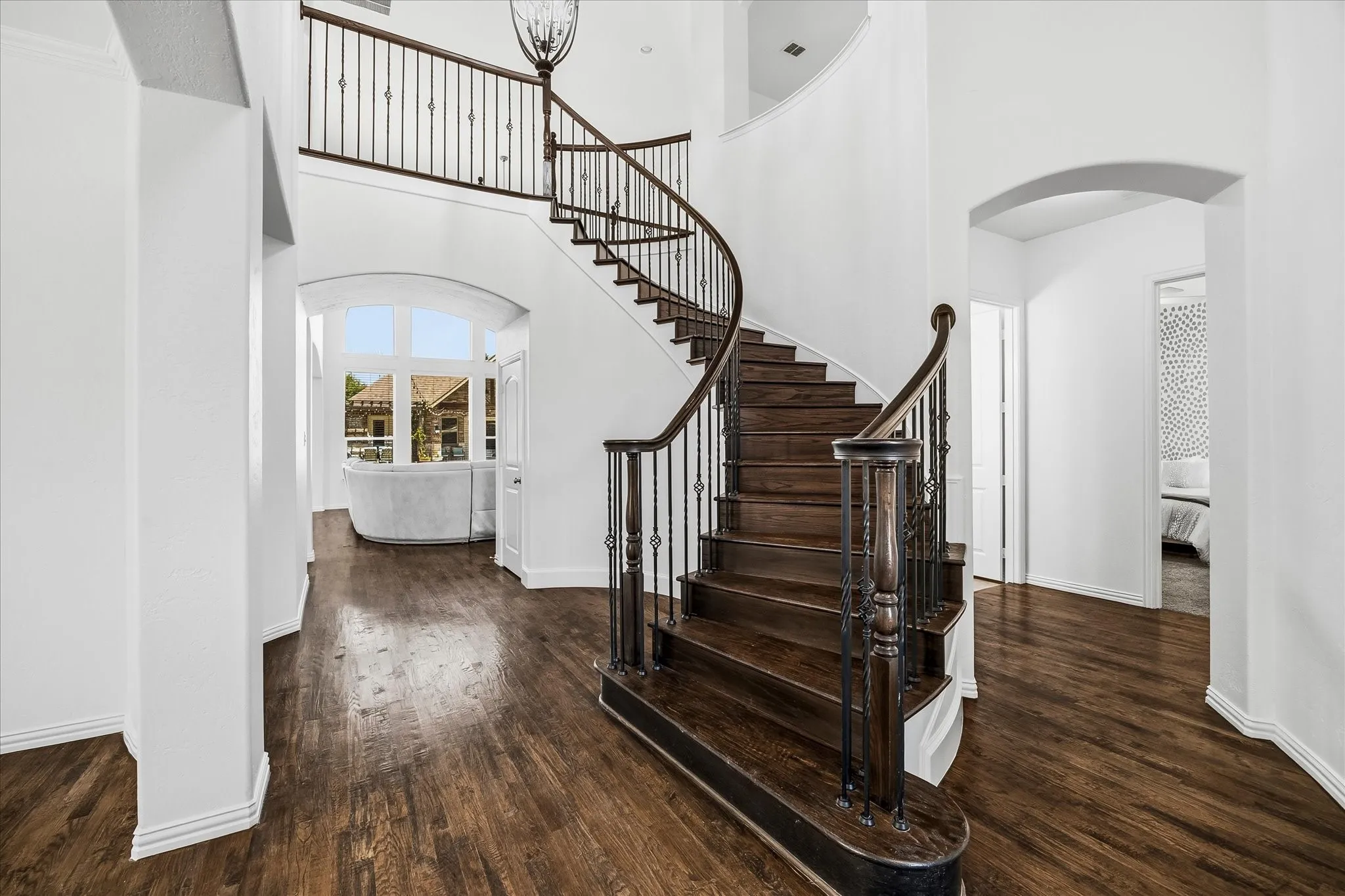 The curved iron staircase leads to the upstairs catwalk that overlooks the living room and foyer.