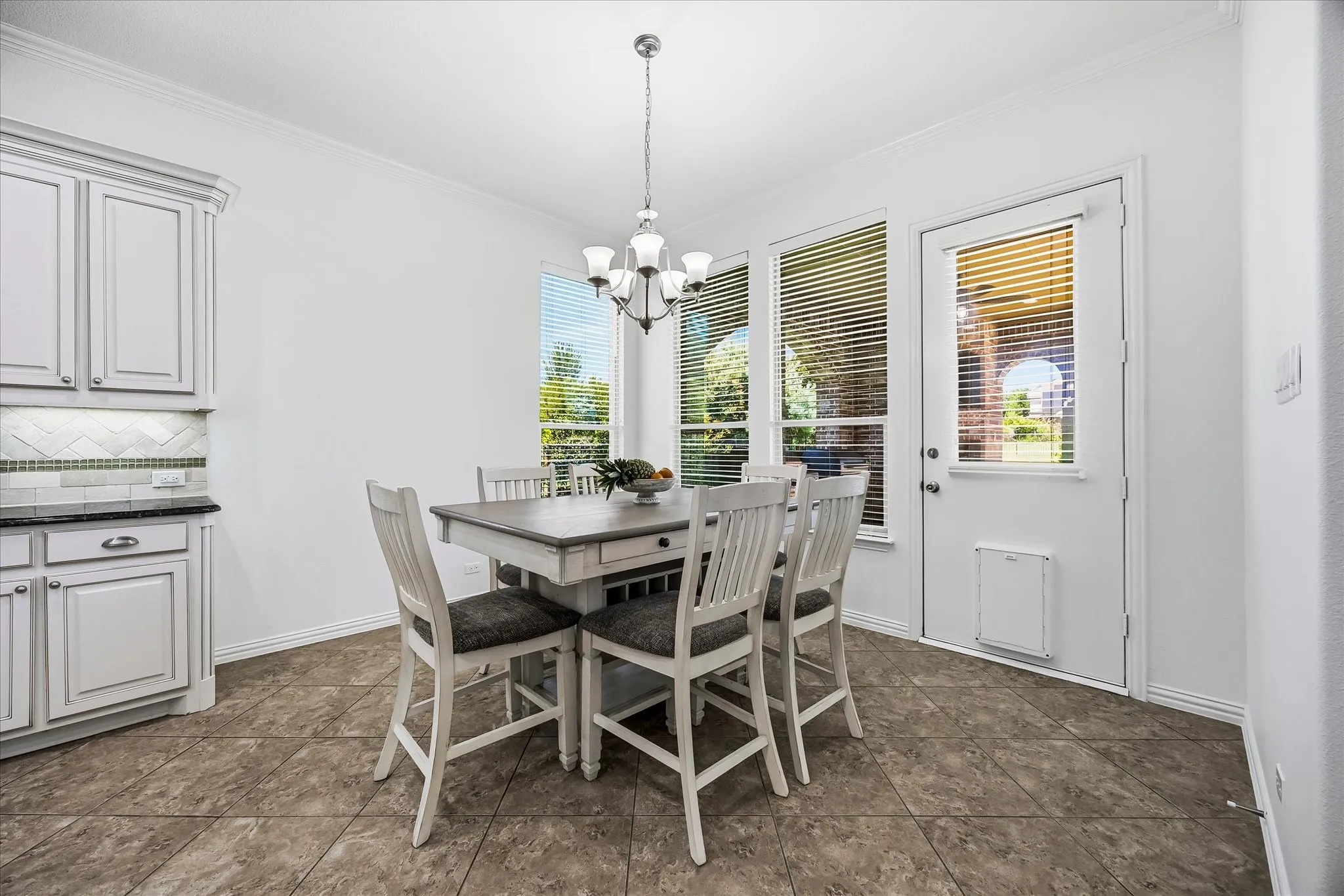 The sunny breakfast nook has a door leading out to the covered patio.