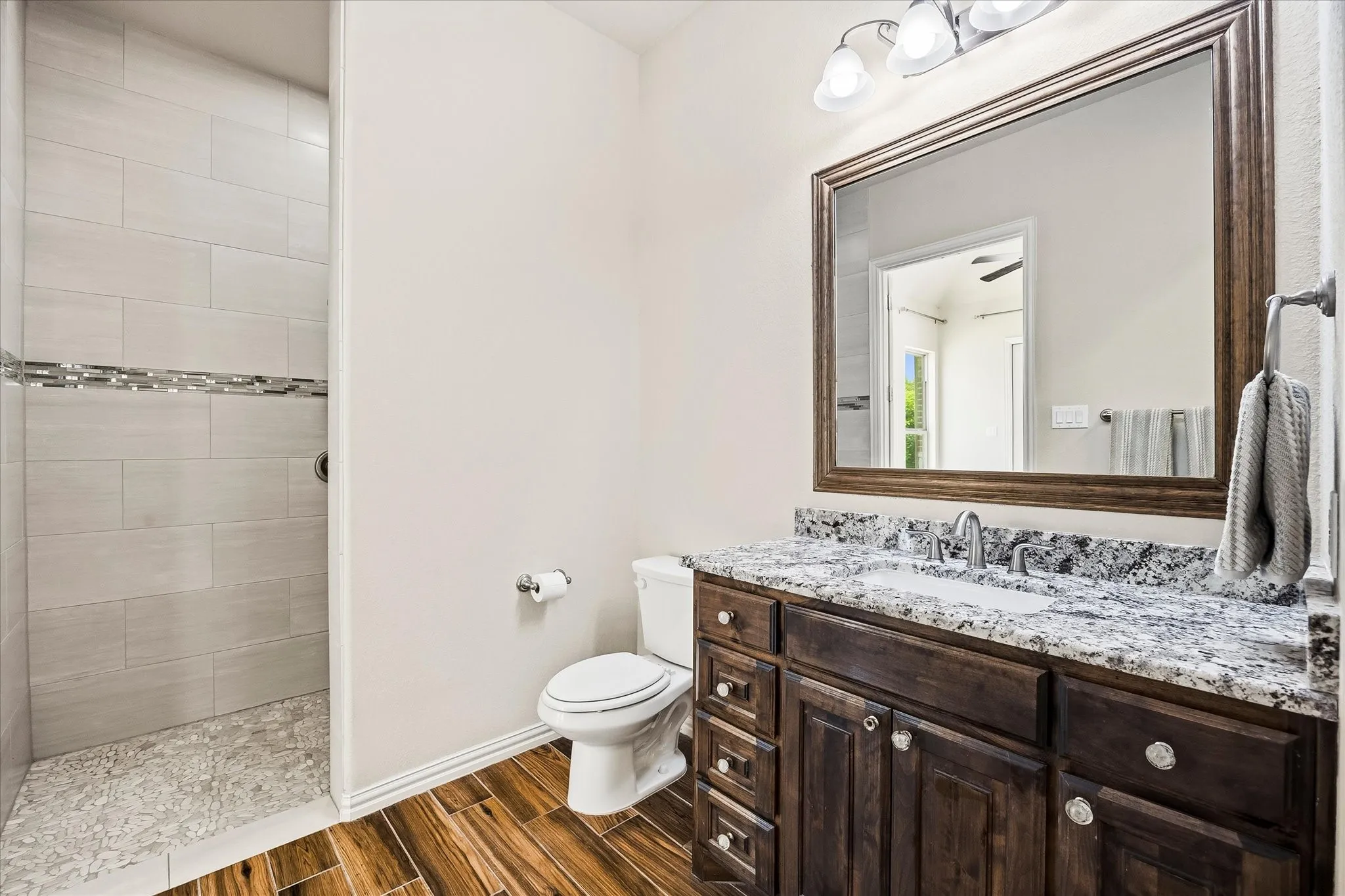 Its ensuite full bath has a roll-in shower with dual shower heads, granite topped vanity and large walk-in closet.