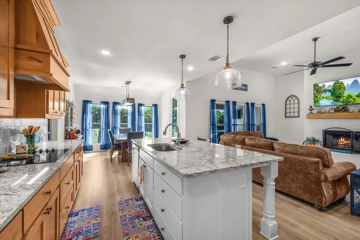Kitchen: Open-concept kitchen offers an oversized island, generous counter space, pendant lighting, and seamless flow to the dining and living areas.