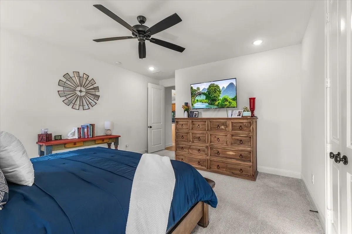 Primary Bedroom: Generously proportioned bedroom features neutral walls, carpeting, recessed lighting, and a ceiling fan.