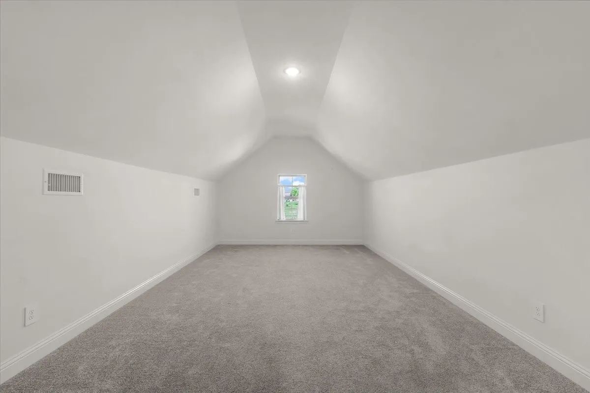 Bonus Room: Expansive upper-level bonus room offers carpeting, a vaulted ceiling, neutral finishes, and flexible open space.