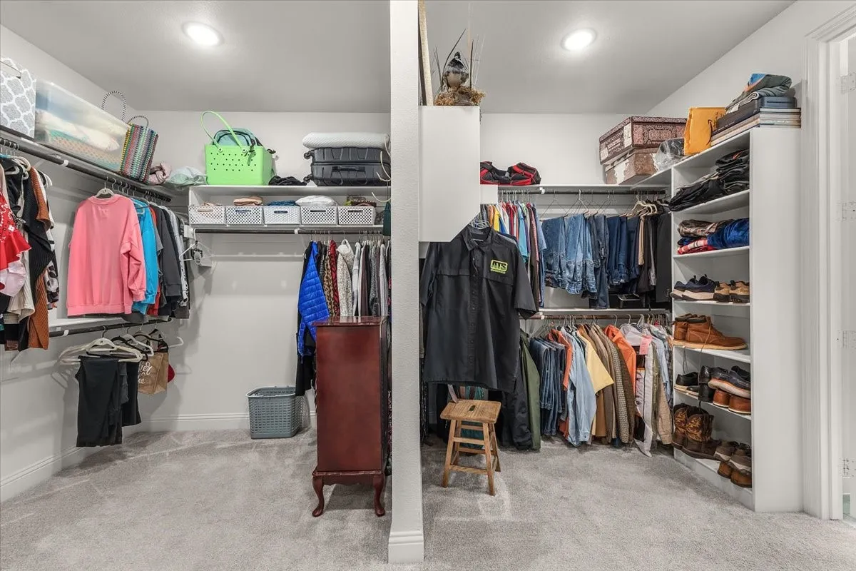 Walk-In Closet: Spacious walk-in closet offers extensive hanging space, open shelving, shoe storage, carpeting, and recessed lighting.