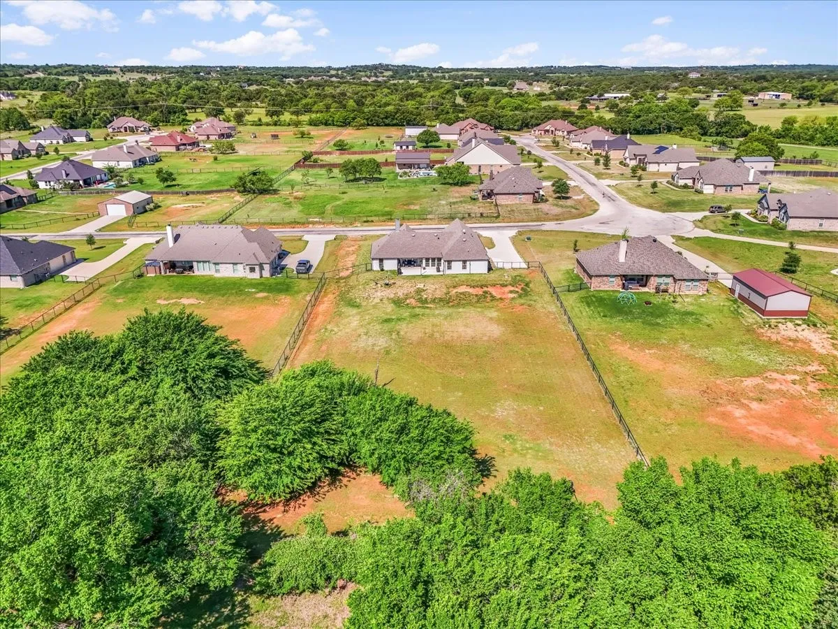 Elevated aerial view showing the home’s approximately 1-acre setting and surrounding Springtown area.