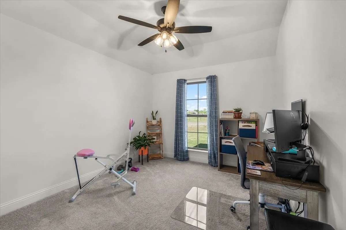 Bedroom: Carpeted bedroom features neutral finishes, a ceiling fan, and a large window providing natural light.