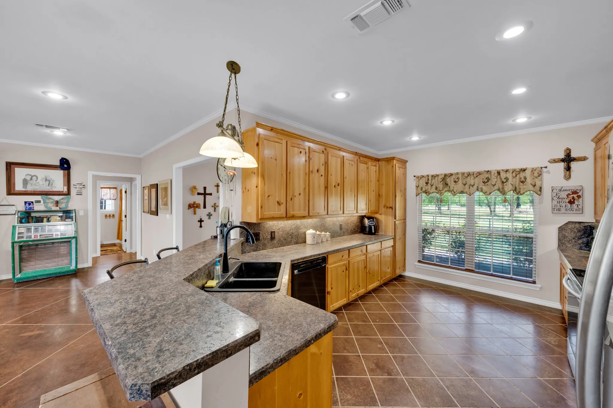 Kitchen featuring wood cabinetry, stone-finish countertops, a built-in dishwasher, a black sink with a gooseneck faucet, and recessed lighting