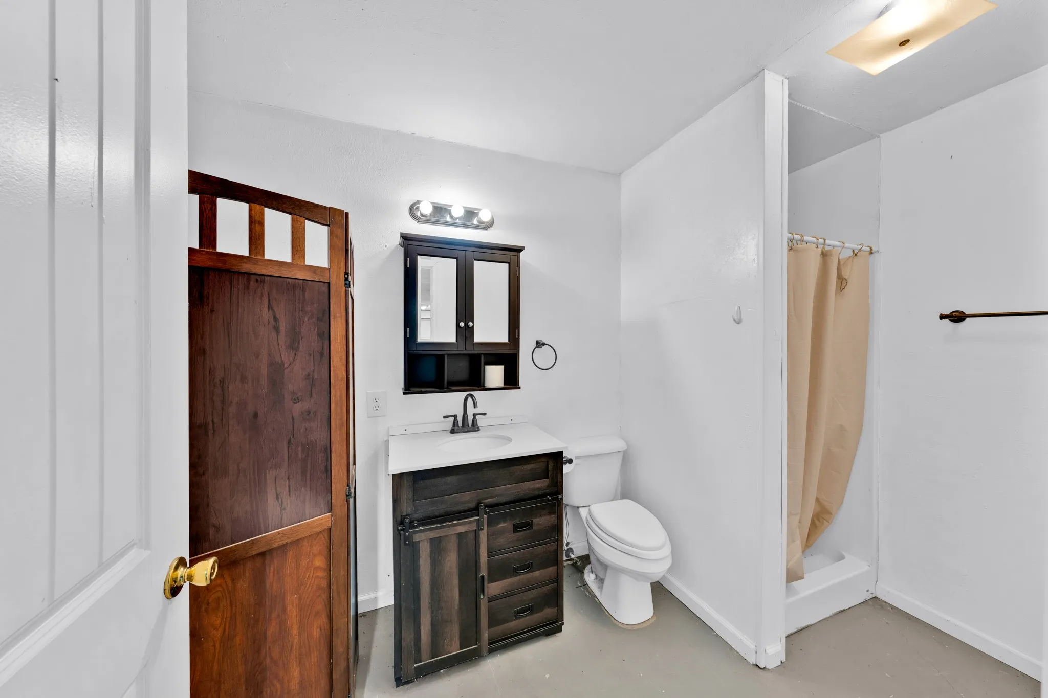 Dark wood-finish vanity with a white countertop and dark-finish faucet